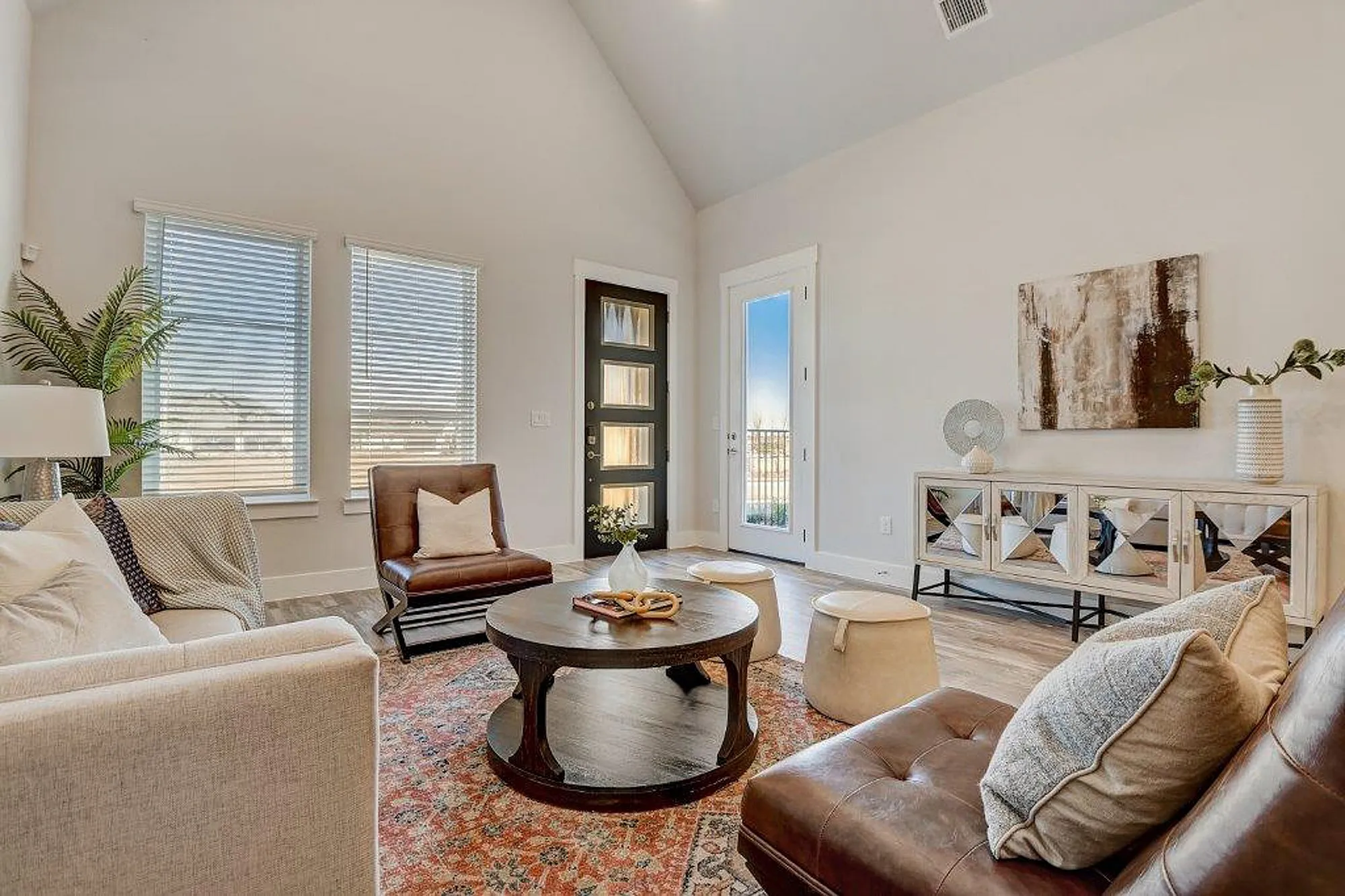Furnished living room with windows, door to patio, couch, rug and sitting chairs