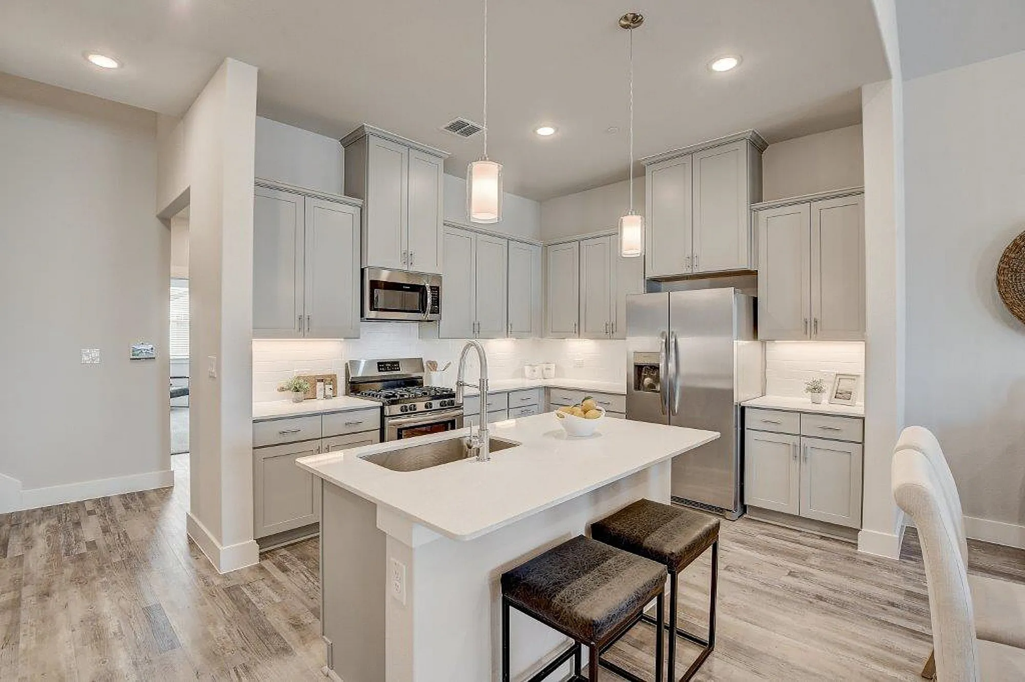 Kitchen with light grey cabinets and stainless steel applicances with kitchen island