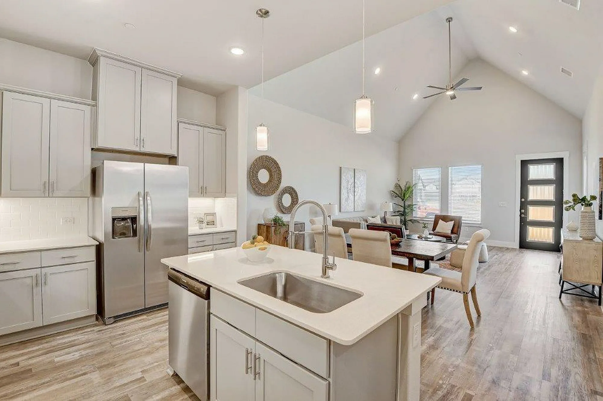 Kitchen with light grey cabinets and stainless steel applicances with kitchen island with view of the living room