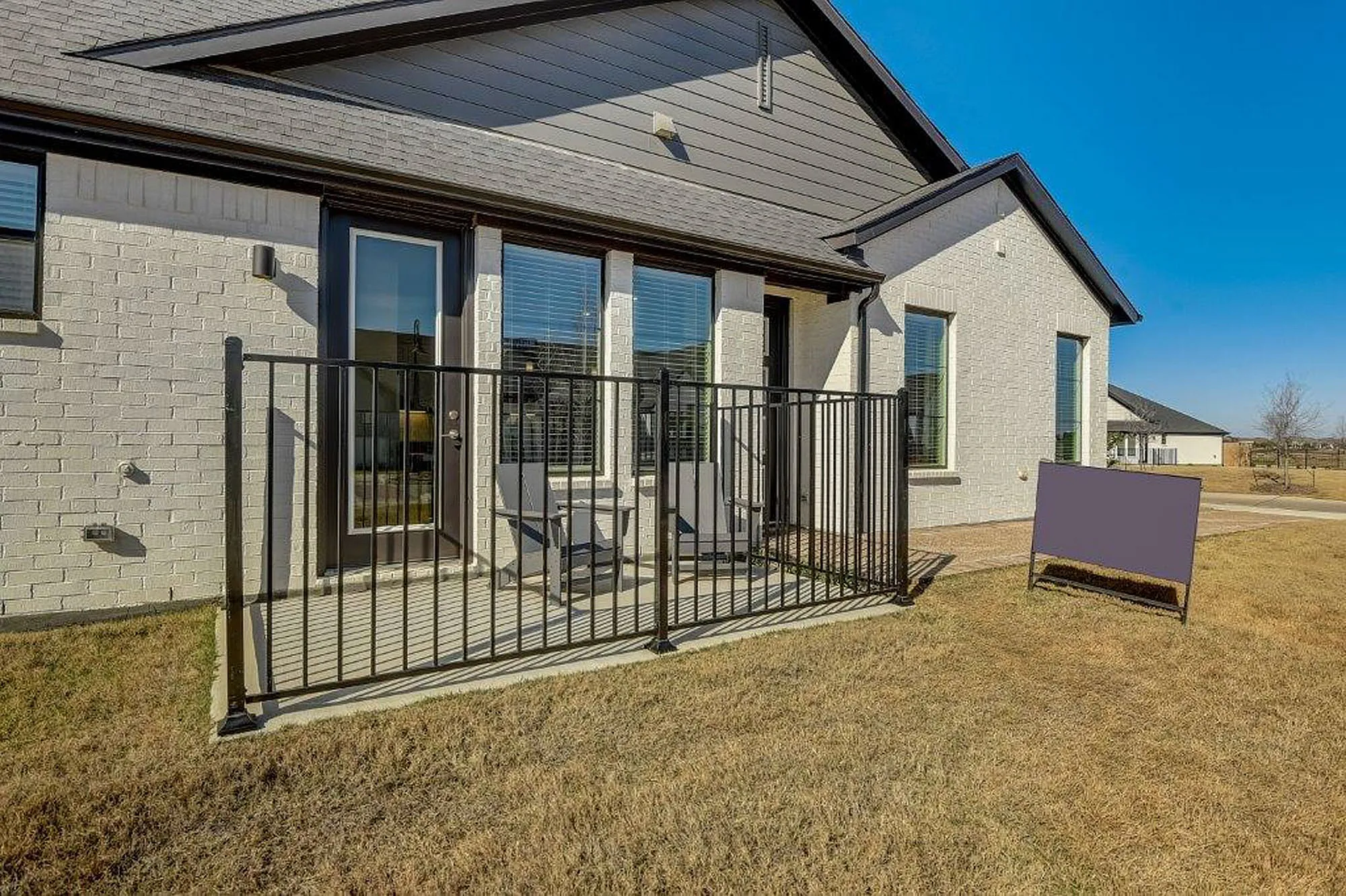 Exterior view of fenced in paved patio outside of a home