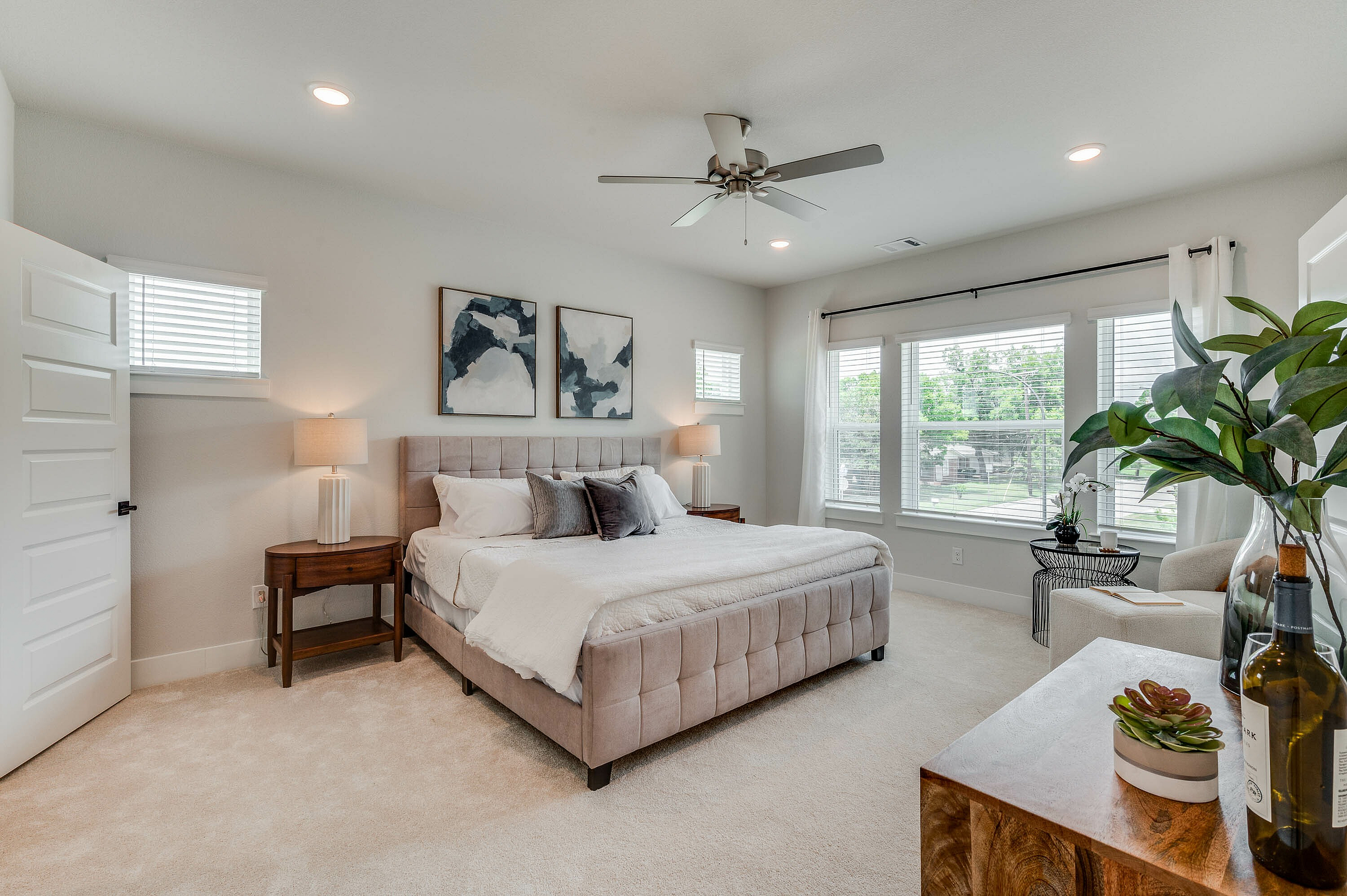 furnished primary bedroom with large windows and carpet