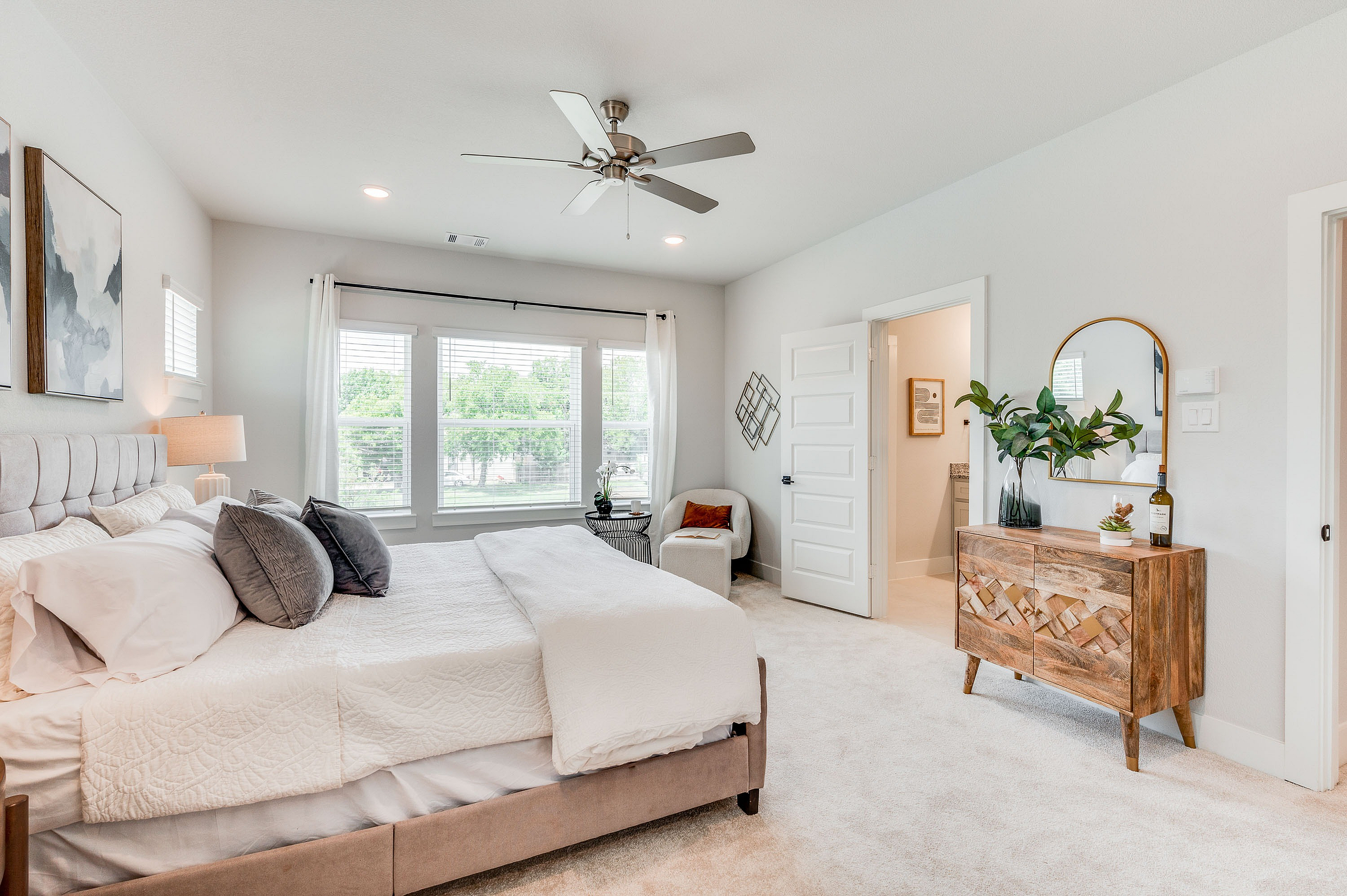furnished primary bedroom with large windows and carpet