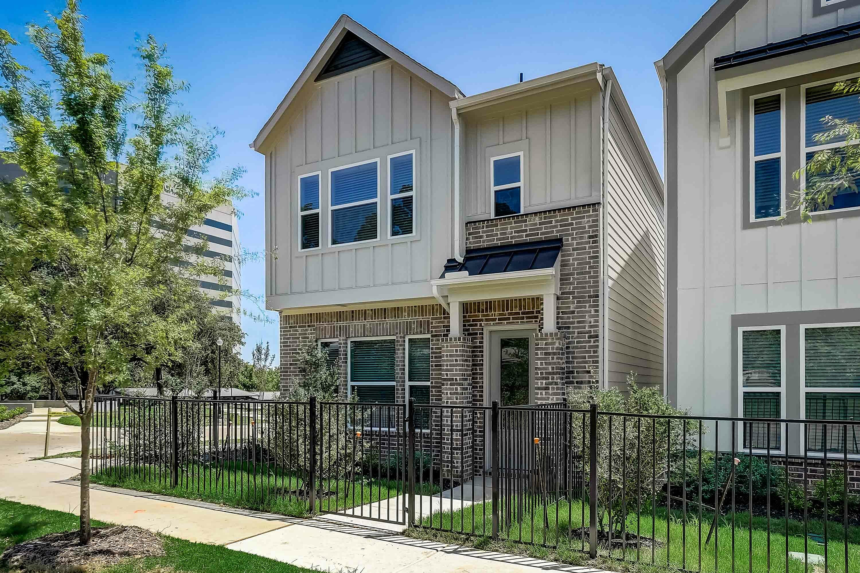 two story home exterior with fenced front yard