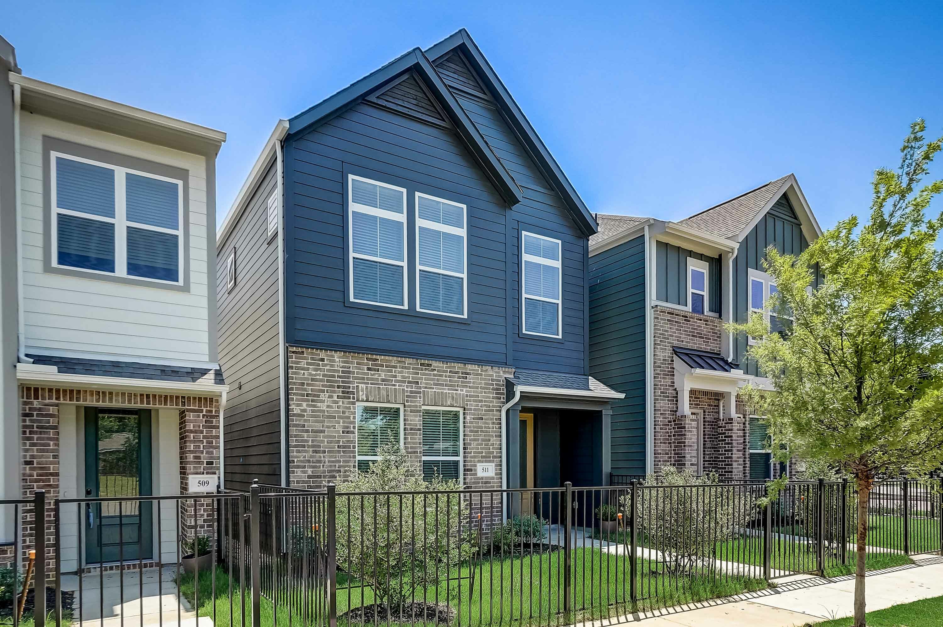 Home exterior with green grass and fenced front yard