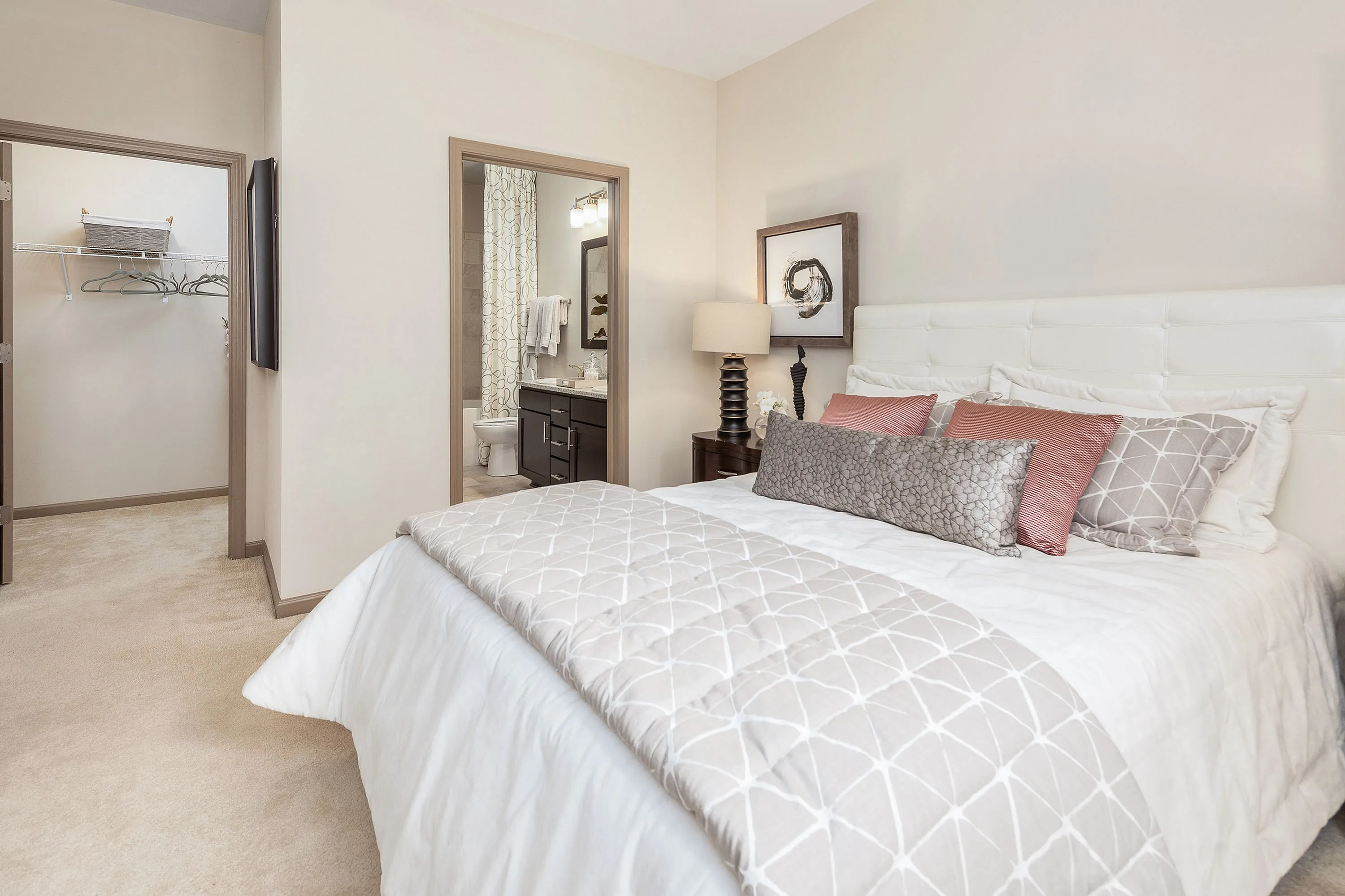 Luxurious bedroom suite with plush bedding, stylish decor, and an en-suite bathroom.