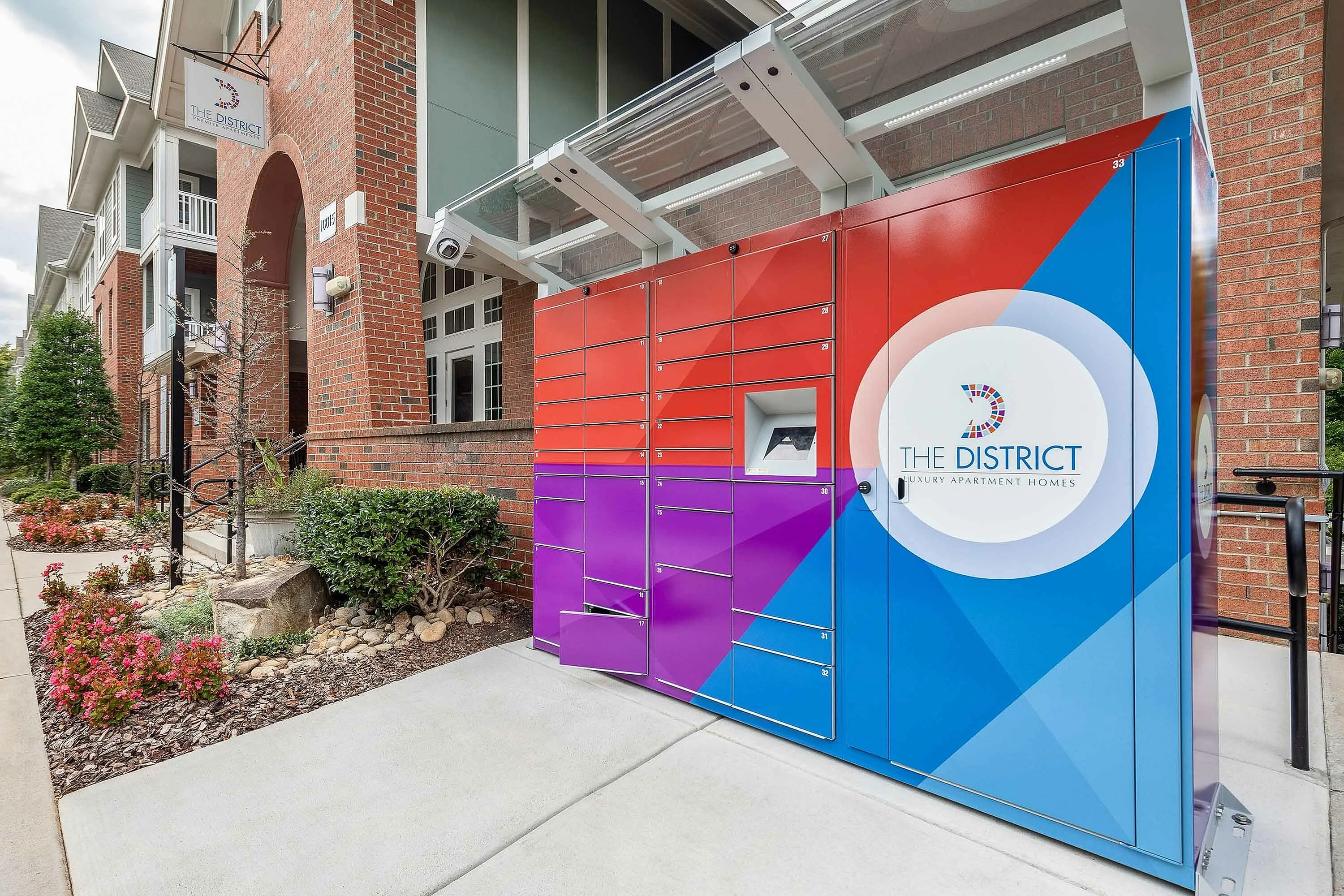 Contemporary apartment complex with modern package locker system at The District Luxury Apartment Homes.