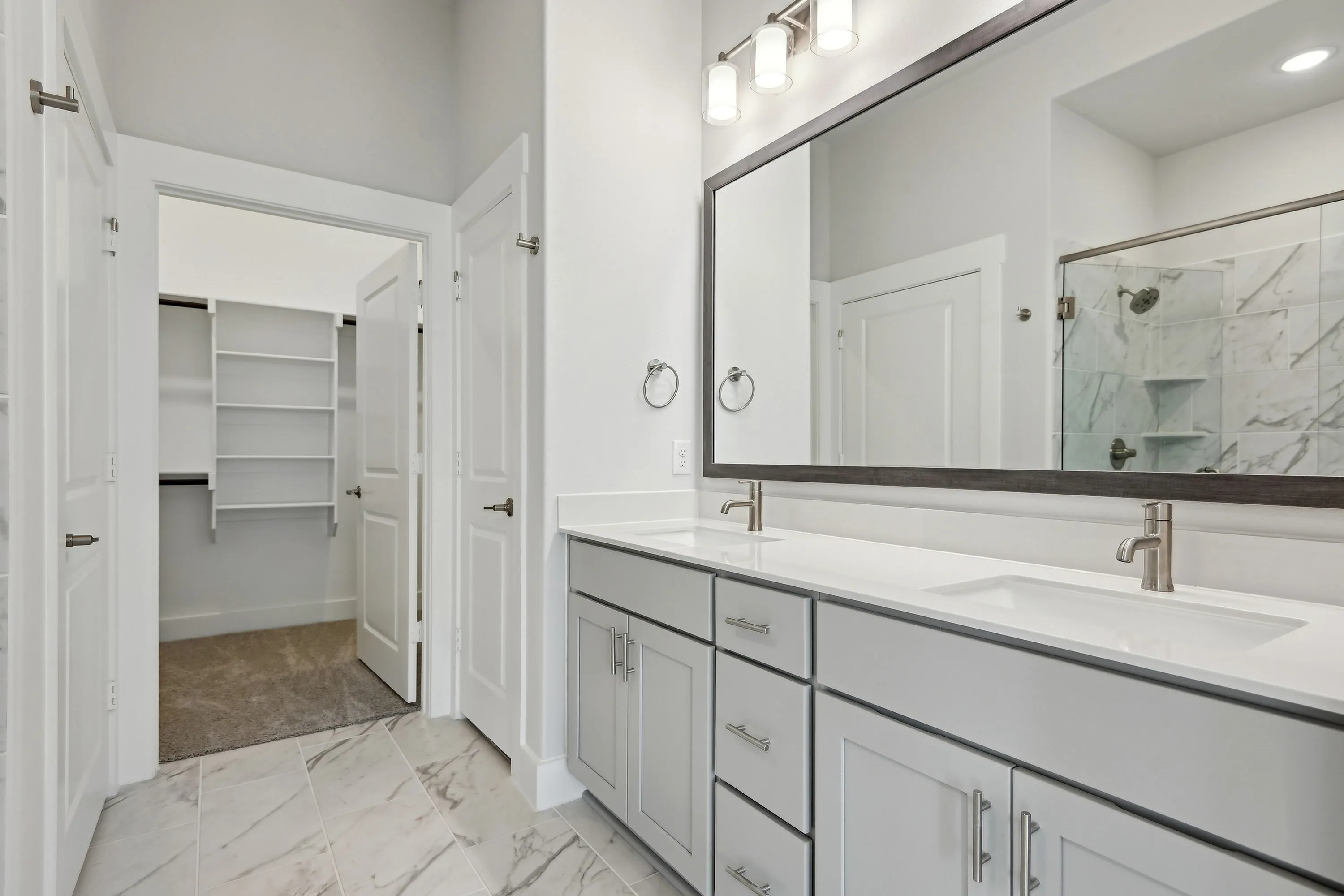 main bathroom with dual vanity and closet