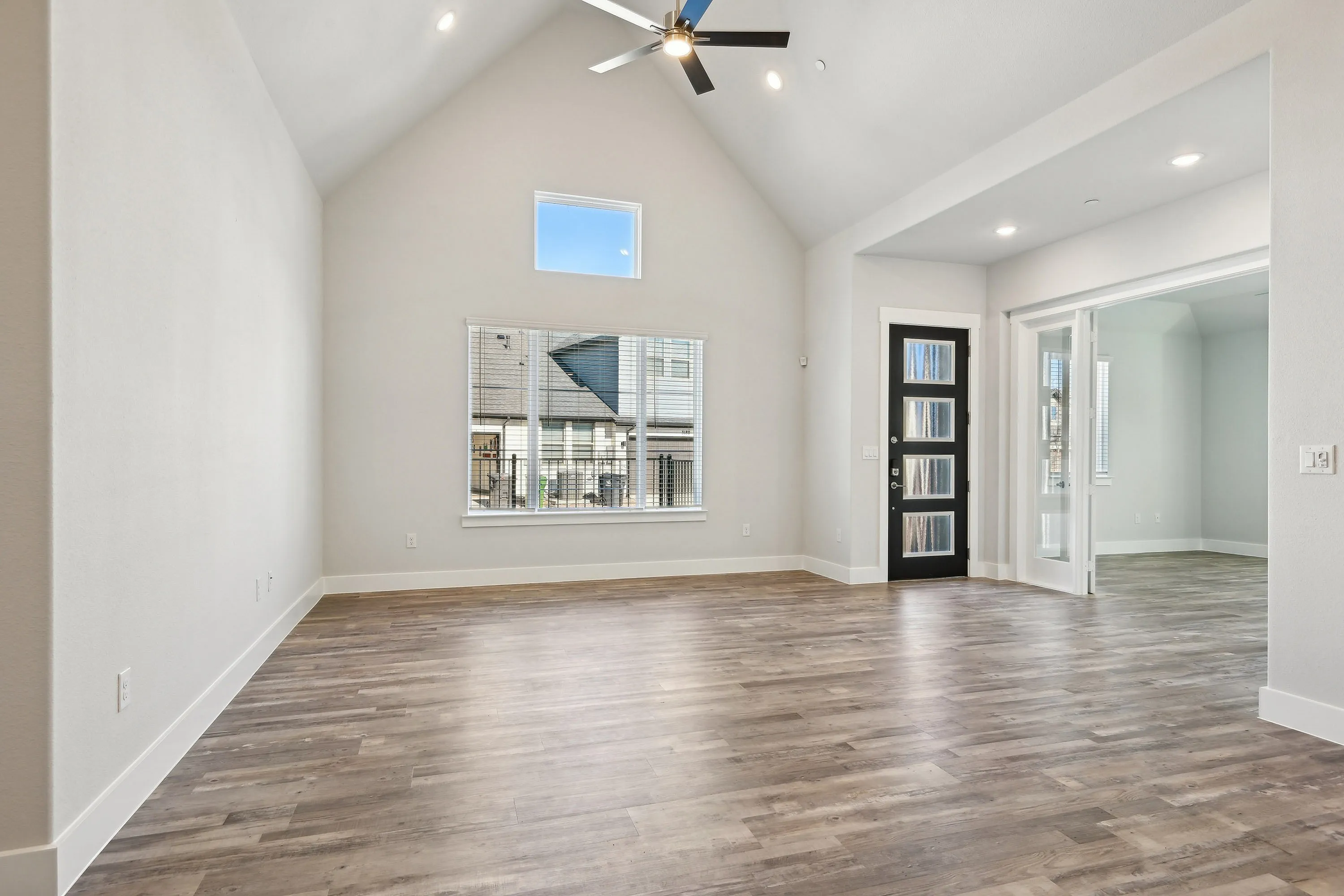 Spacious living area with vaulted ceiling and and french door opening