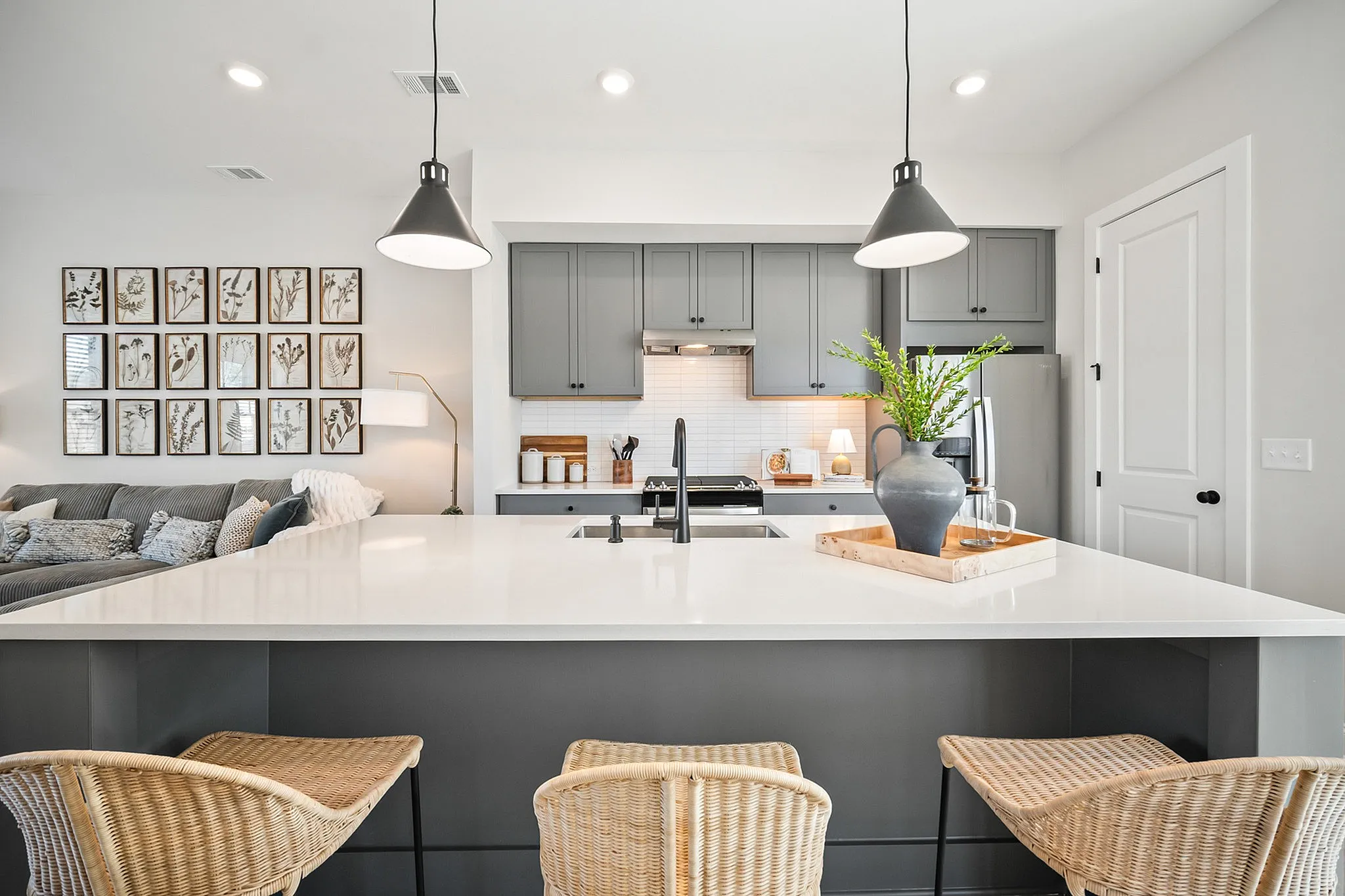 Furnished kitchen with grey cabinets and large island