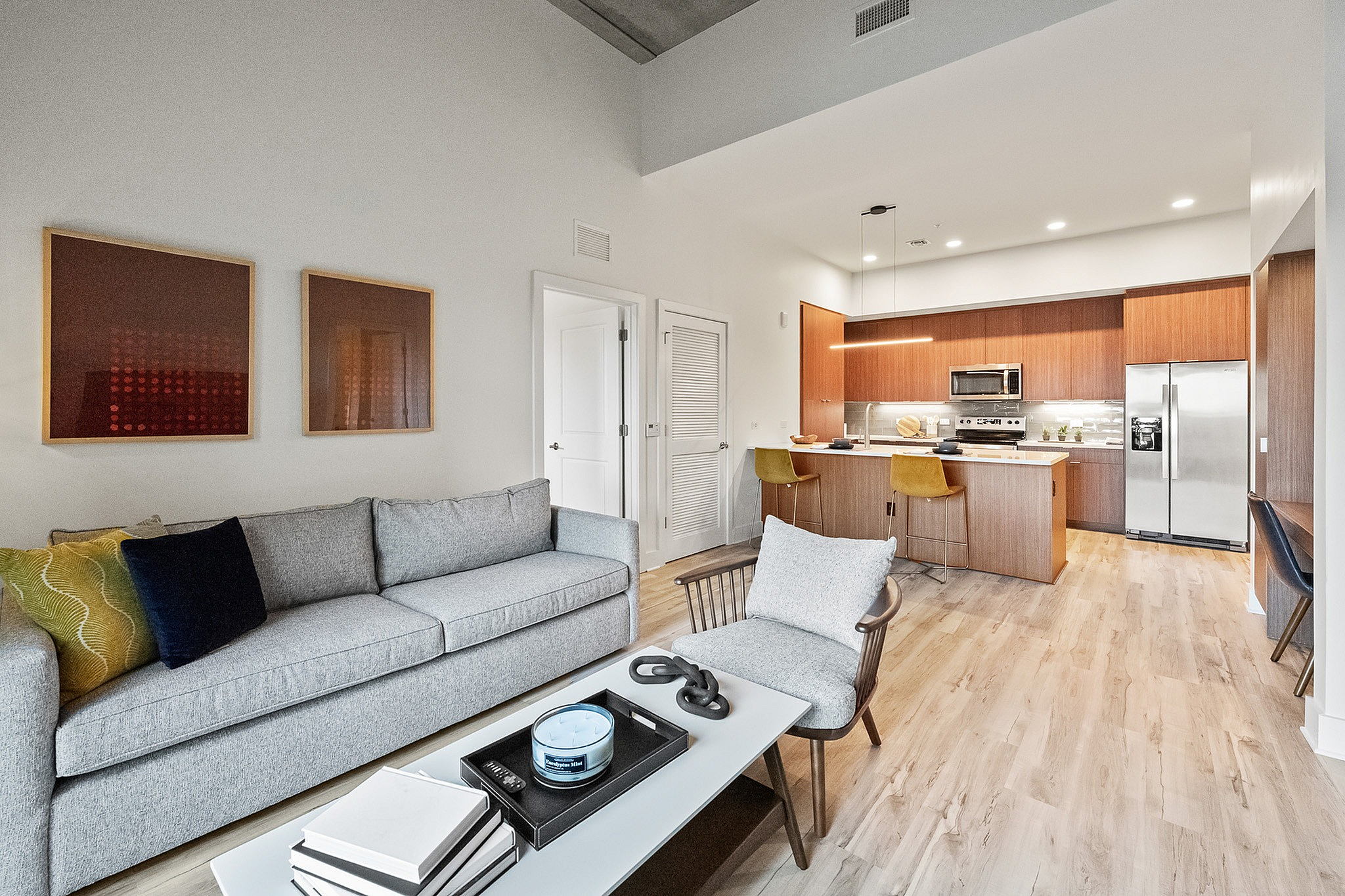 Stylish living room looking into modern kitchen with breakfast bar