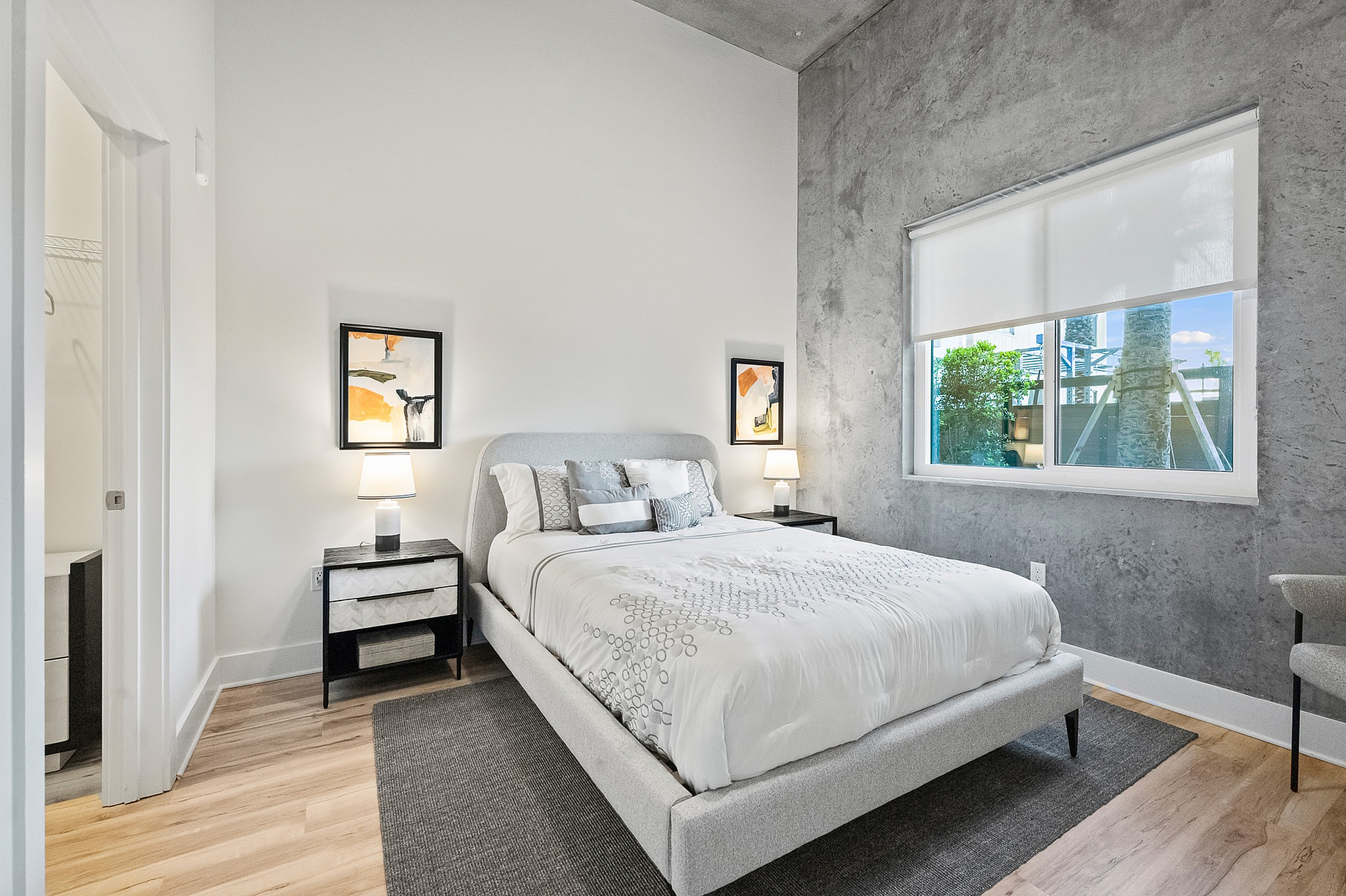 One-Bedroom Luxury Apartments Viera FL - Luna At Viera - Guest Bedroom Featuring High Ceilings, Accent Wall, and Wood-Style Flooring