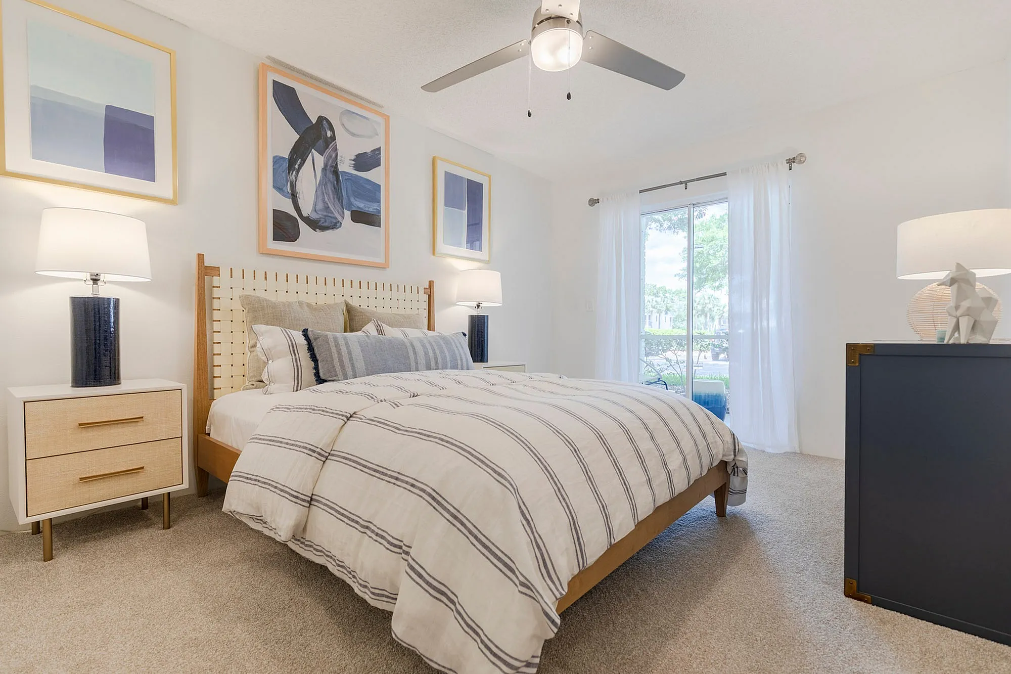 Furnished bedroom with bed and dresser and access to balcony