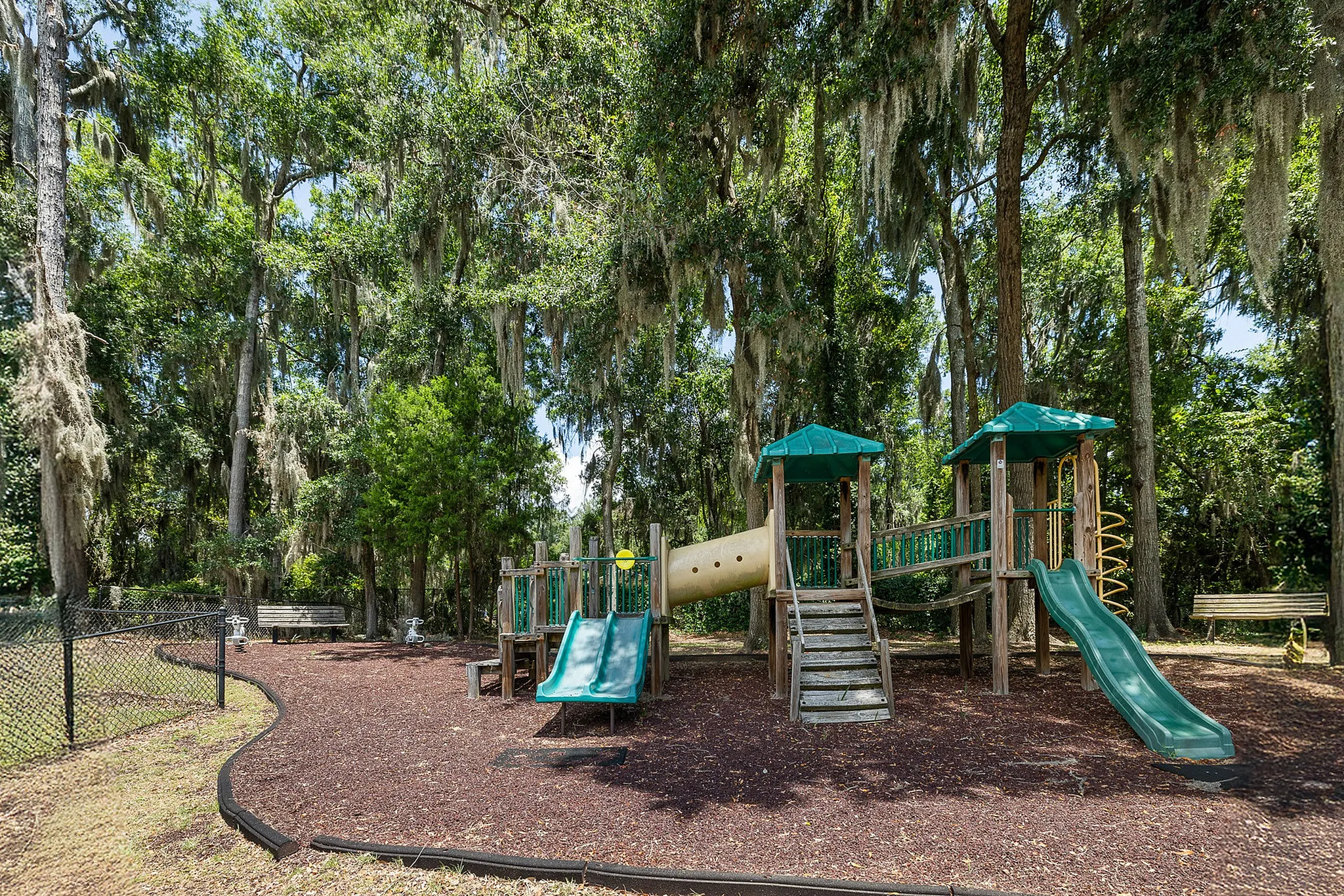 Port Royal, SC, Apartments Near Marine Corps - Preserve at Port Royal - Shaded Community Playground With Slides, Climbing Structure, Mulch Ground Cover, And Mature Trees Draped In Spanish Moss.