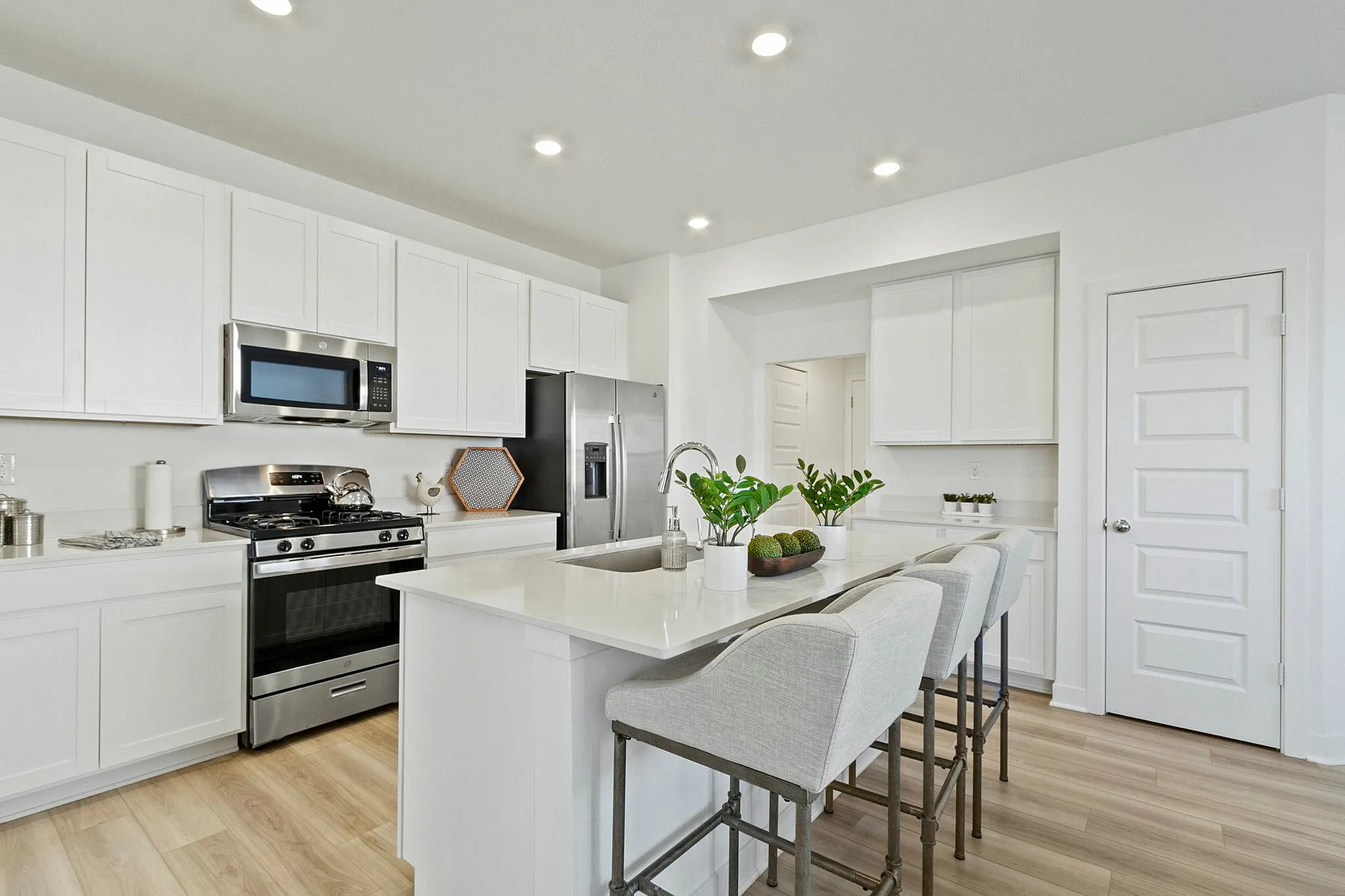 Furnished kitchen with large island and white cabinetry