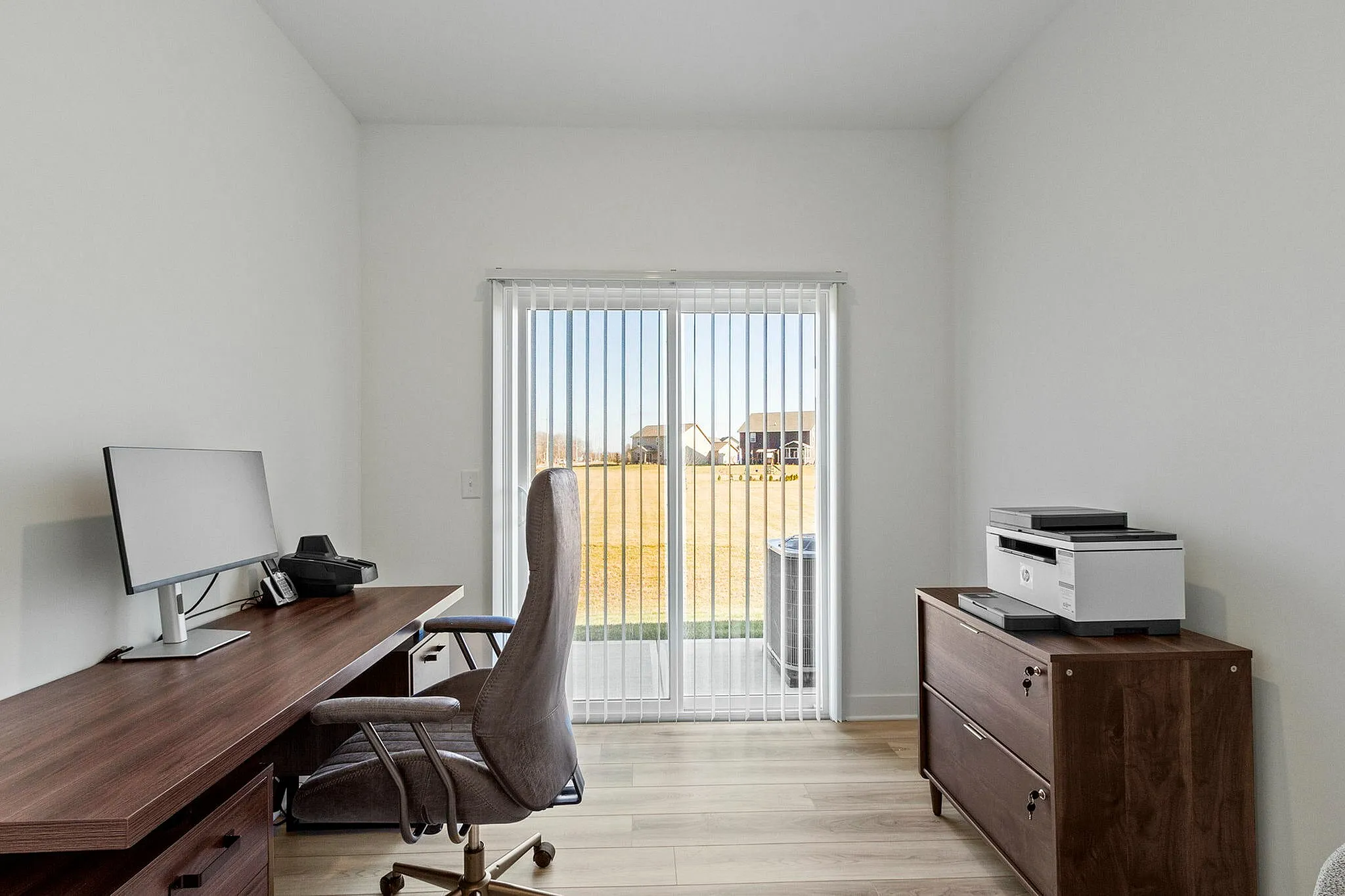 Furnished office with desk and drawer and sliding glass door