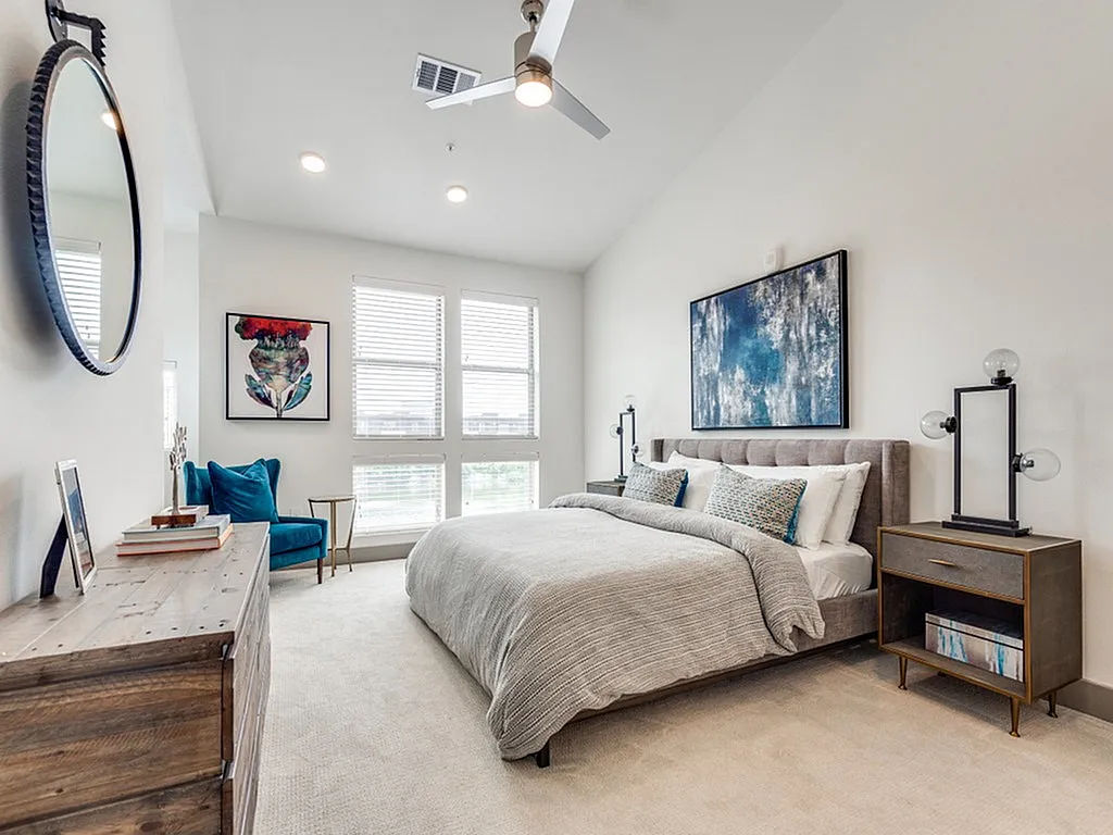 Main bedroom with large bed and carpet and tall ceilings