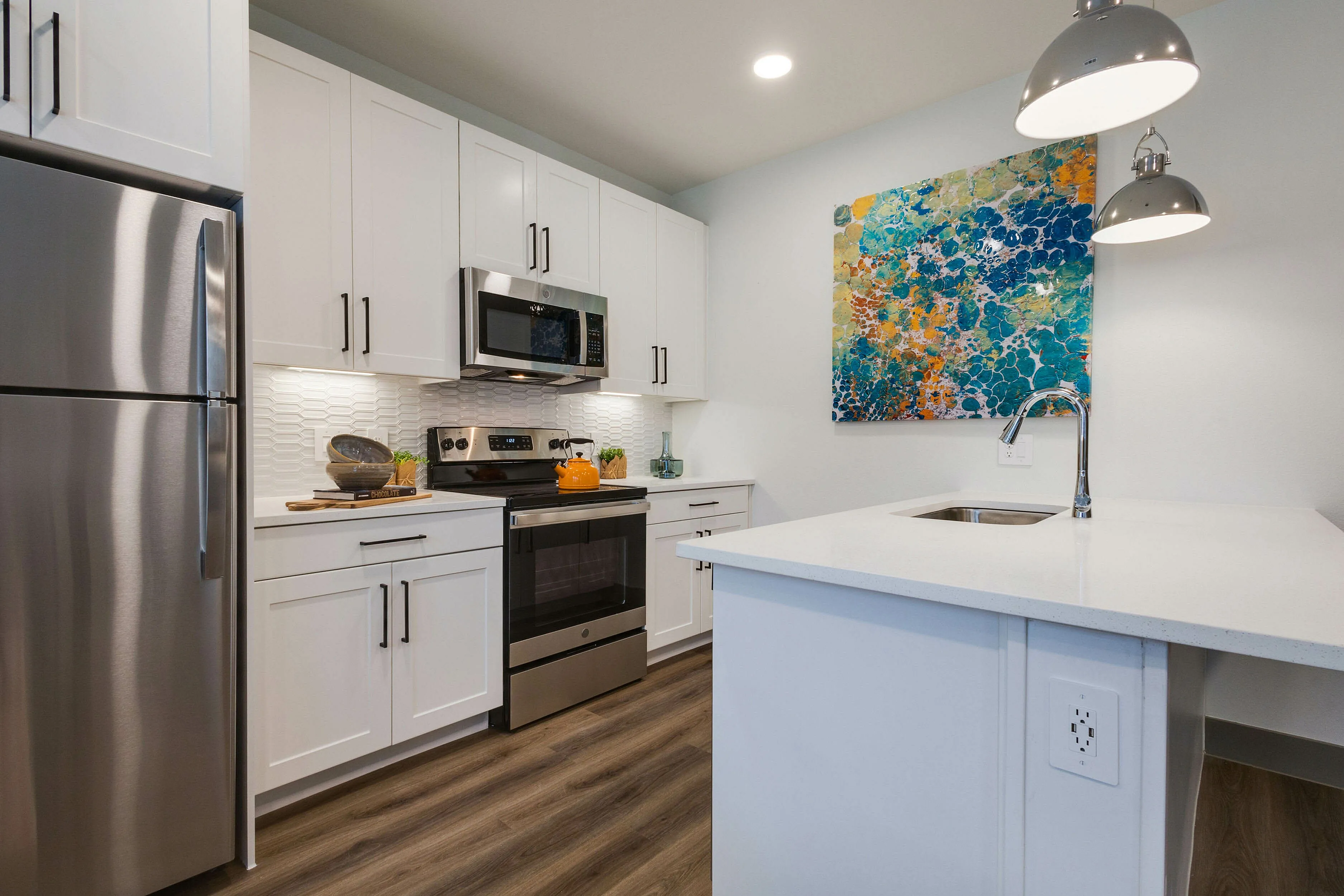 Decorated modern kitchen with stainless stee appliances and white cabinetry