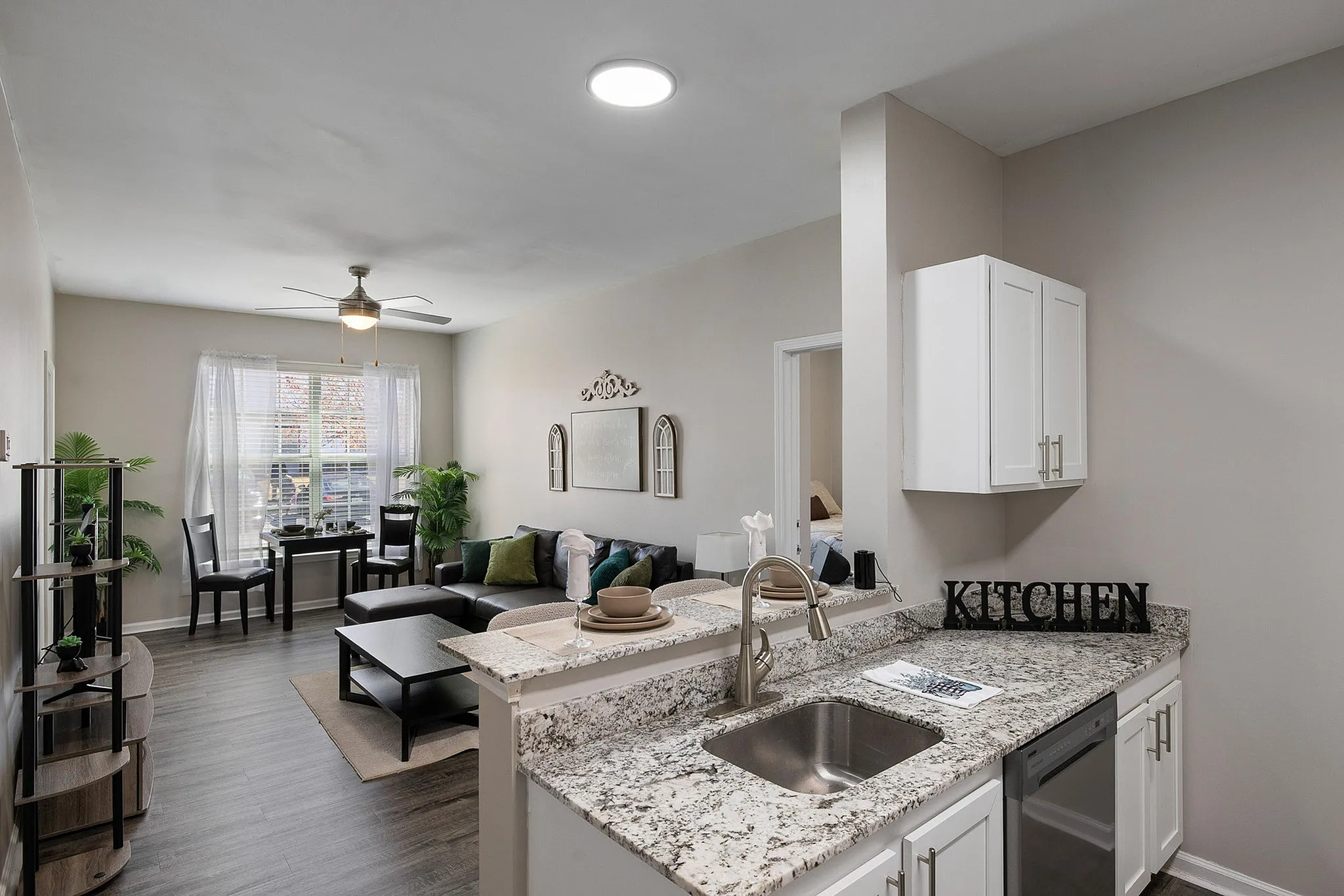 Open model kitchen overlooking living room with black couch