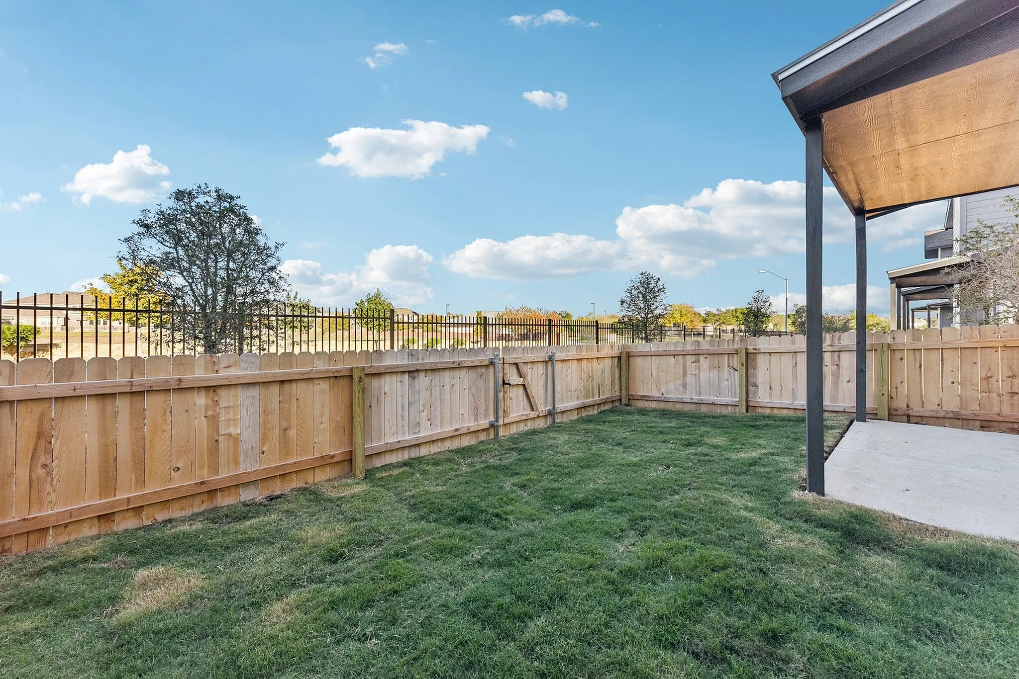 North Austin, TX, Townhomes, with In-Unit Washer and Dryer - Lone Oak Homes - Backyard With Privacy Fence, Green Lawn, Covered Patio Slab, And Open Sky Views.