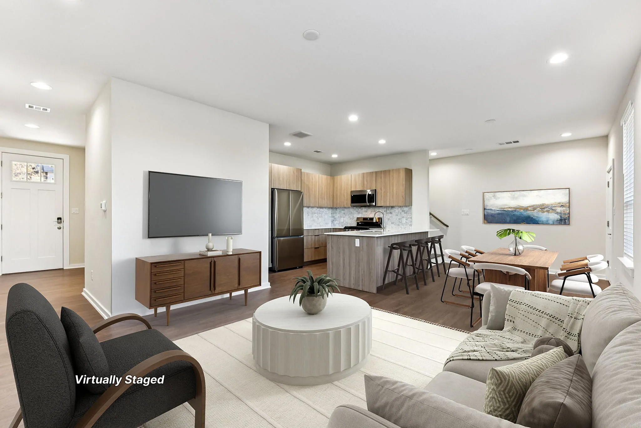 Townhomes in North Austin, TX, with In-Unit Washer and Dryer - Lone Oak Homes - Open Concept Living Room With Sofa, Armchair, Coffee Table, TV, Media Console, And View Of Dining Area And Kitchen.