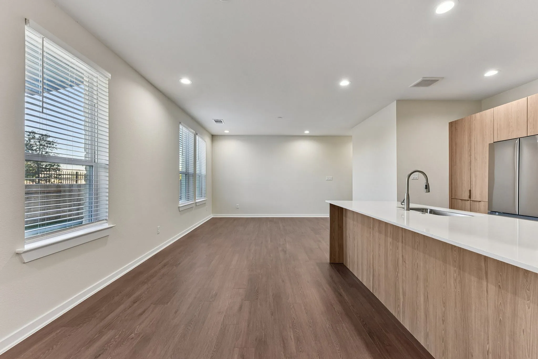 Kitchen with light wood cabinets and living room space