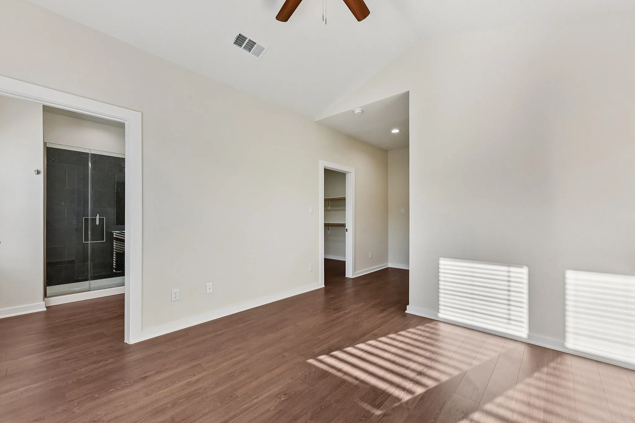 Bedroom with ceiling fan and primary bathroom