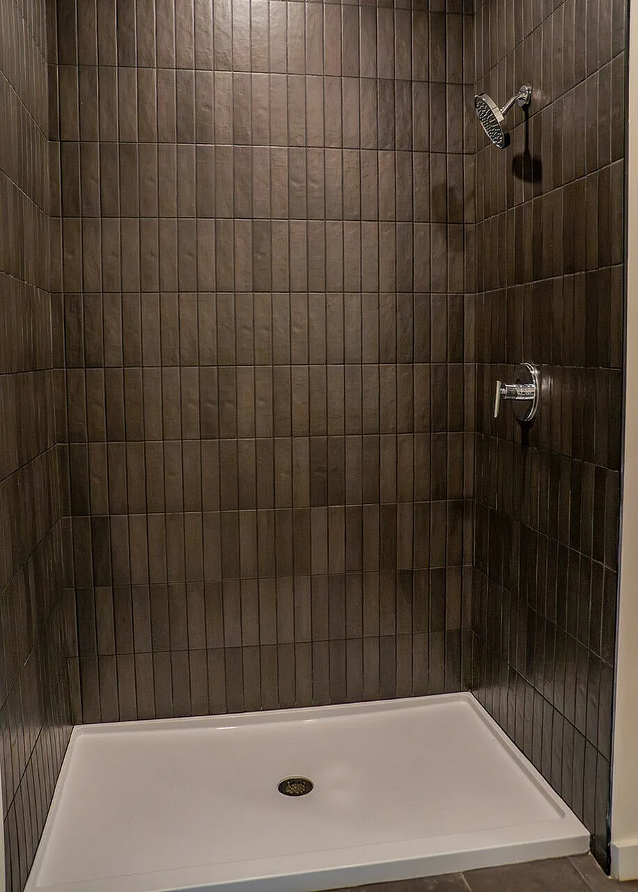 spacious standing shower with upscale tiling