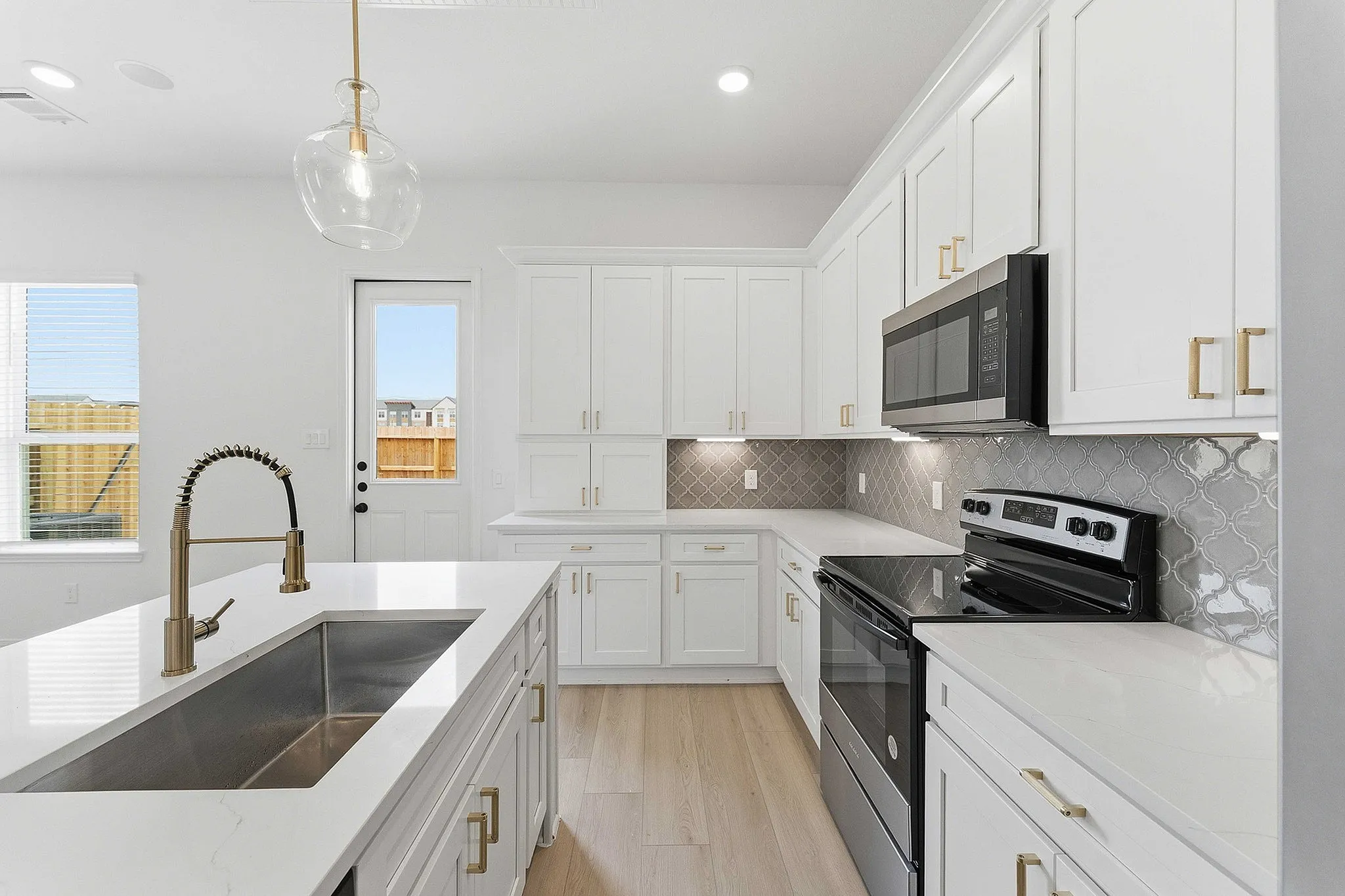 interior of kitchen with white cabinets and gold appliances and hardware
