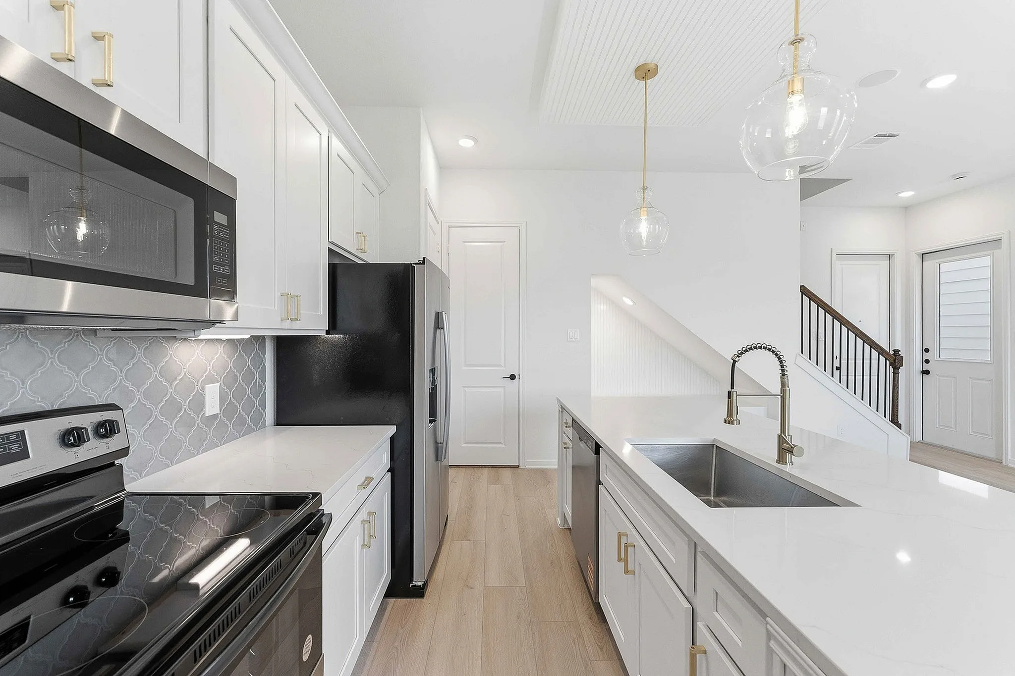 interior of kitchen with white cabinets and gold hardware