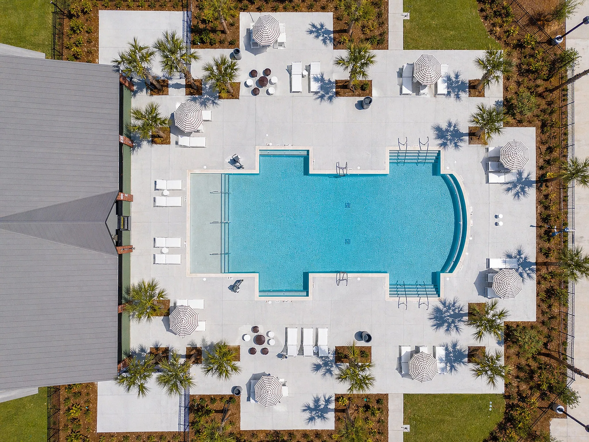 large swimming pool with seating and umbrellas