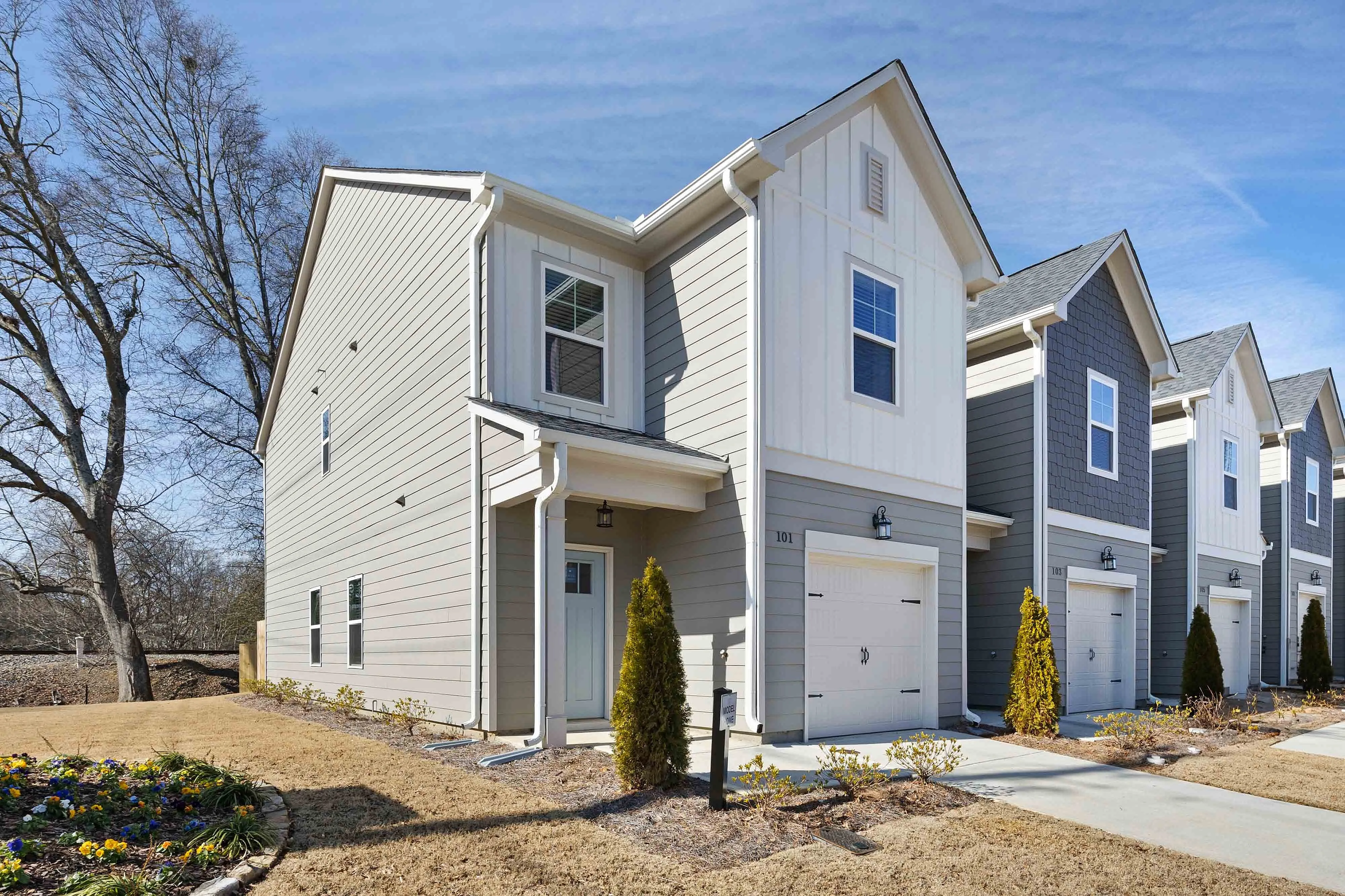 Cartersville, GA, Townhomes with In-Unit Washer and Dryer - Brightside at Cloverleaf - Modern Townhome Exterior With Attached Garages, Multiple Residential Units, And Landscaped Walkways.