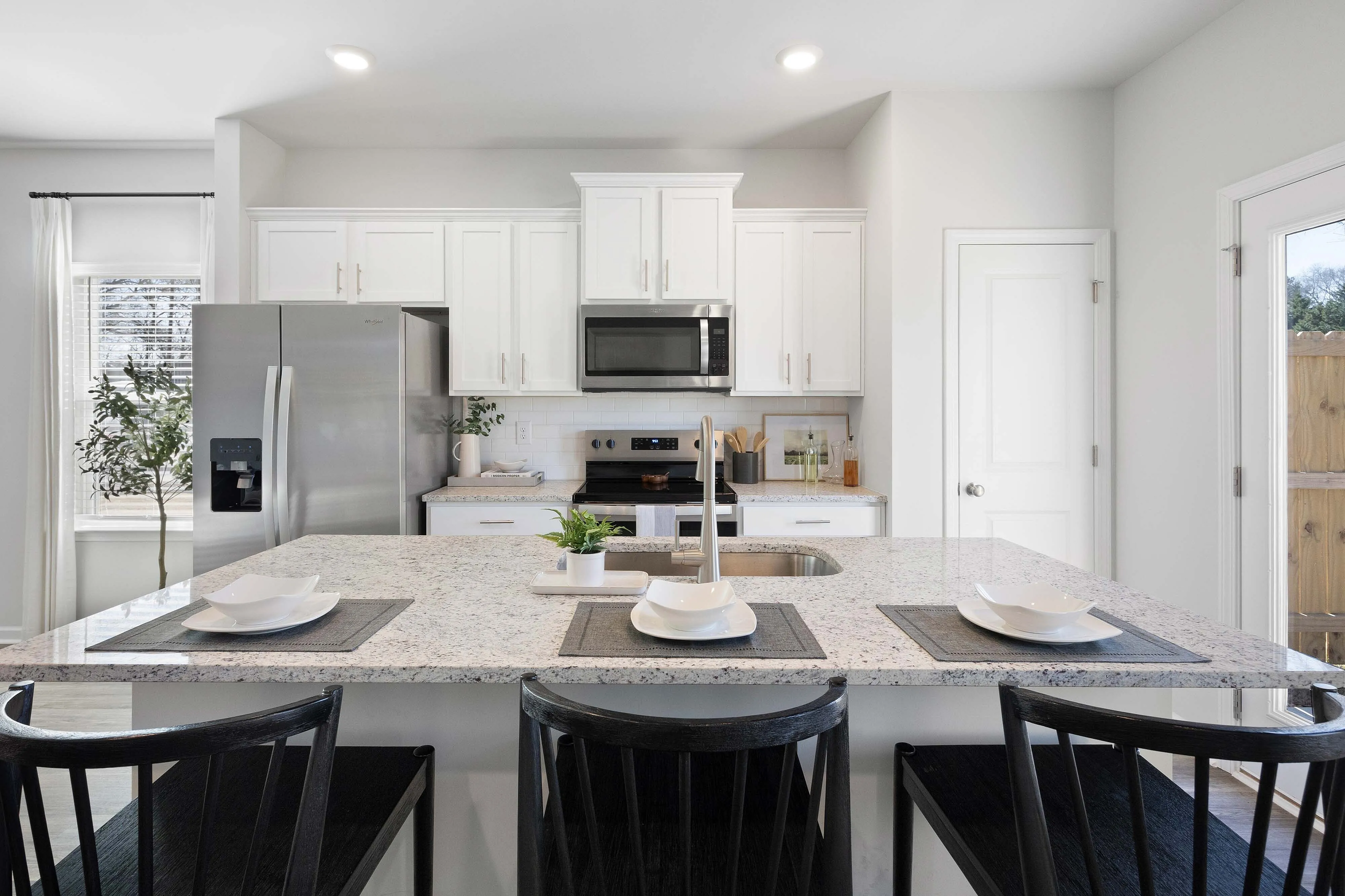 Cartersville, GA, Pet-Friendly Townhomes - Brightside at Cloverleaf - Kitchen With White Cabinets, Stainless Steel Appliances, Granite Countertops, And Large Island With Seating.