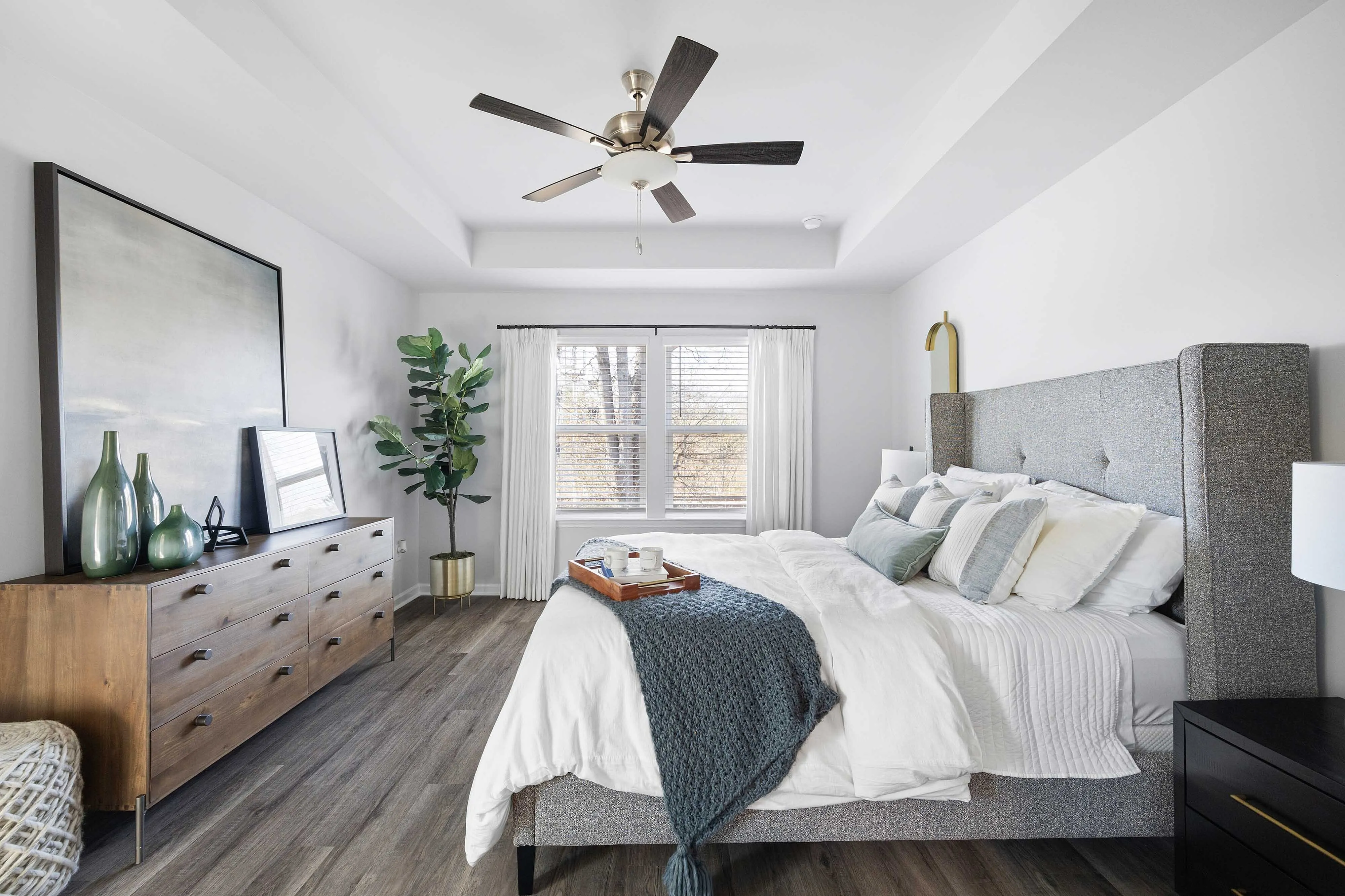 Three-Bedroom Townhomes in Cartersville, GA - Brightside at Cloverleaf - Bedroom With Wood-Inspired Luxury Plank Flooring, A Large Bed, Ceiling Fan, Dresser, And Large Windows.