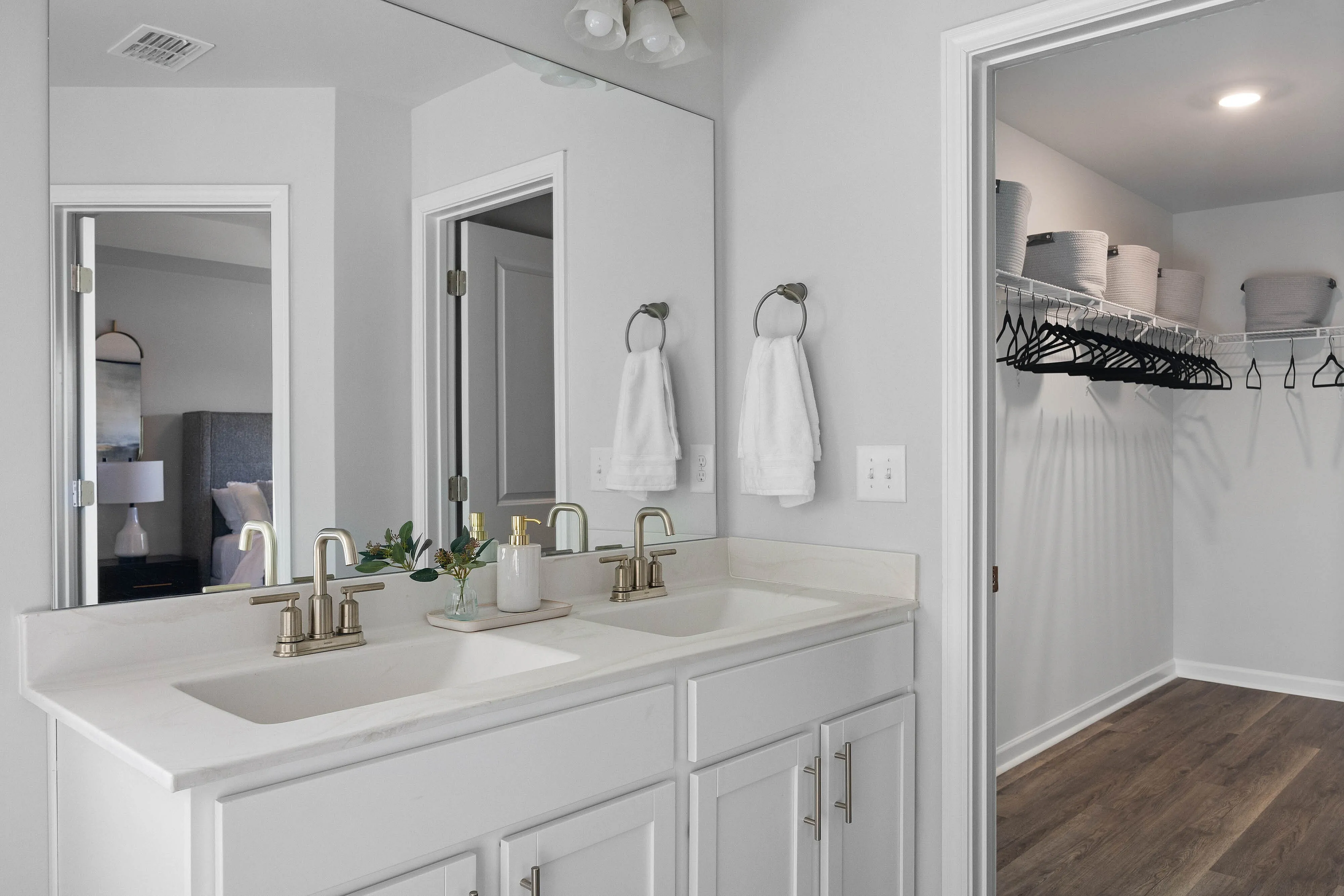 main bathroom with dual vanity and walk in closet