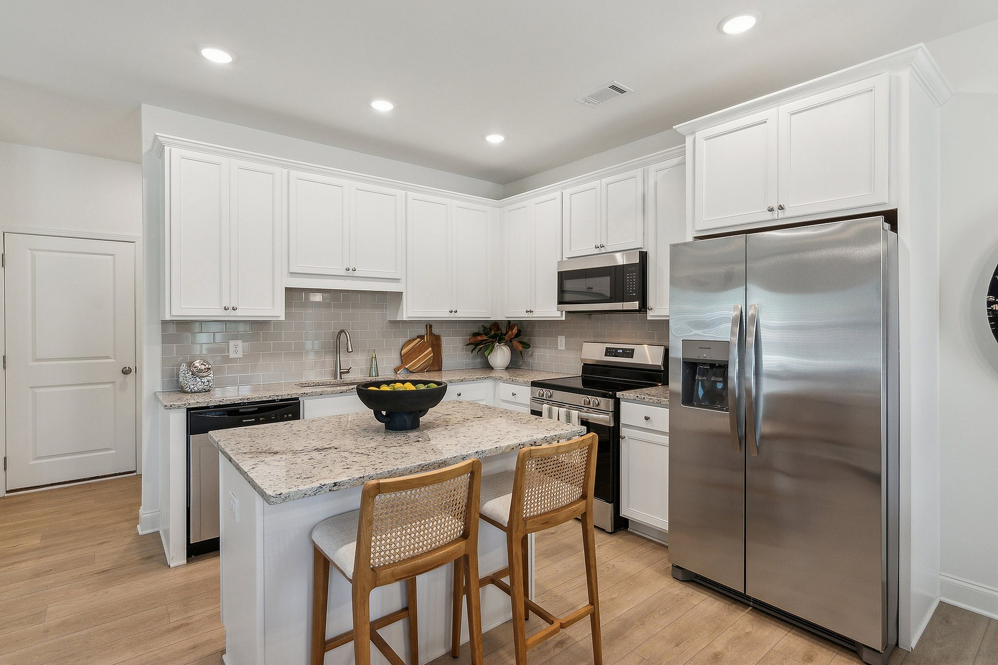 modeled kitchen with barstools and stainless steel appliances