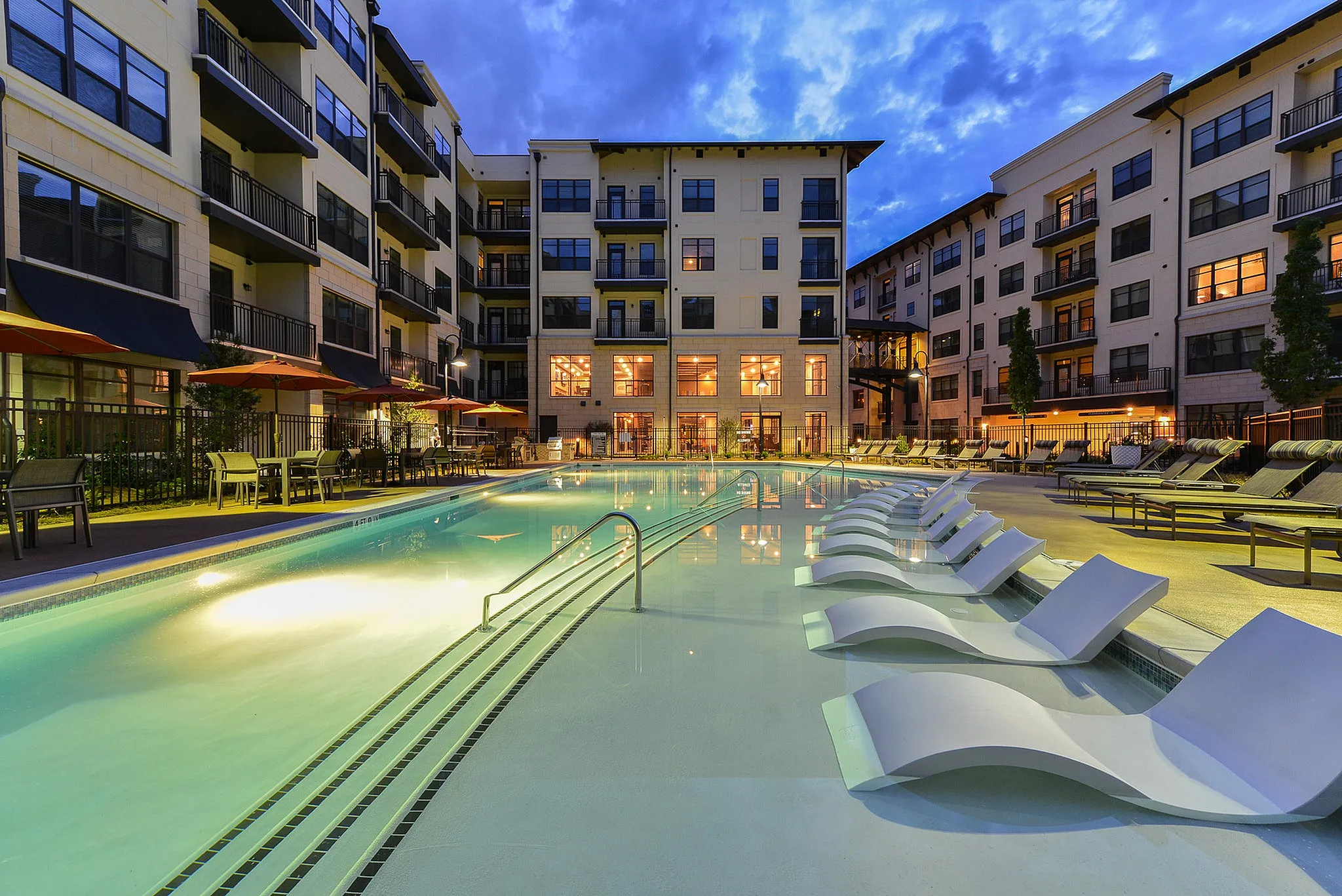 Swimming pool with tanning deck at sunset