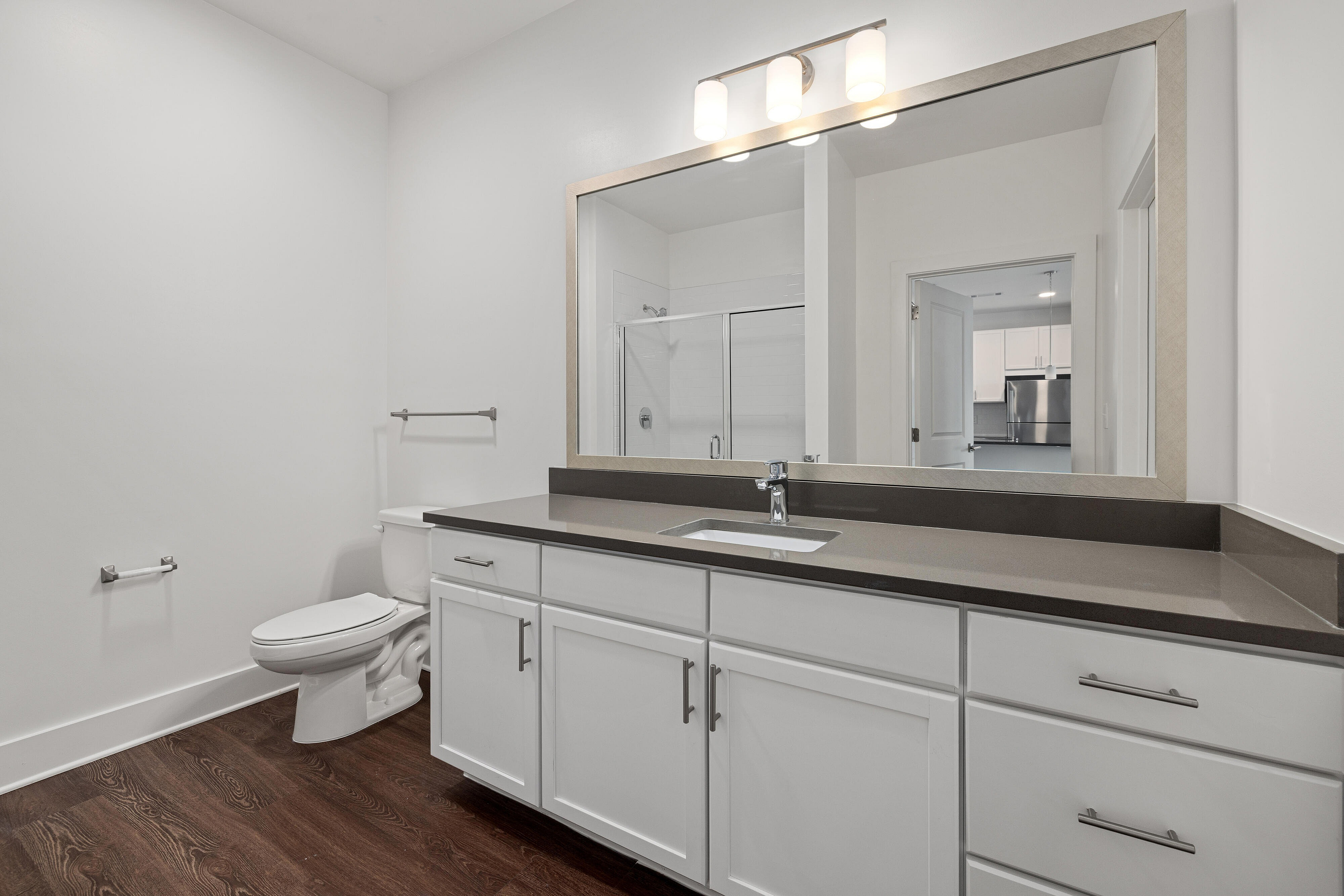 vacant bathroom with gray cabinets and stand up shower