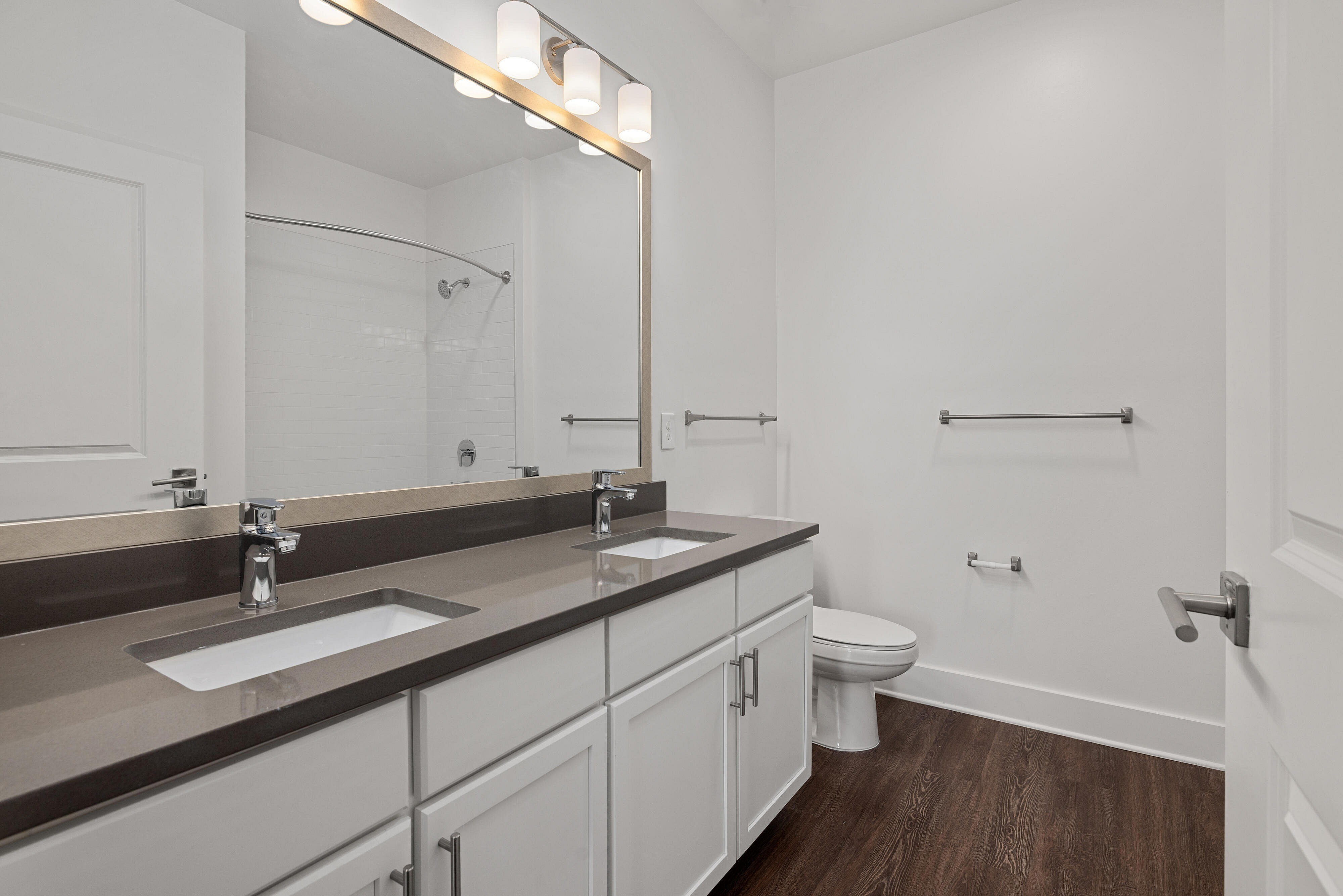 vacant bathroom with gray cabinets and stand up shower