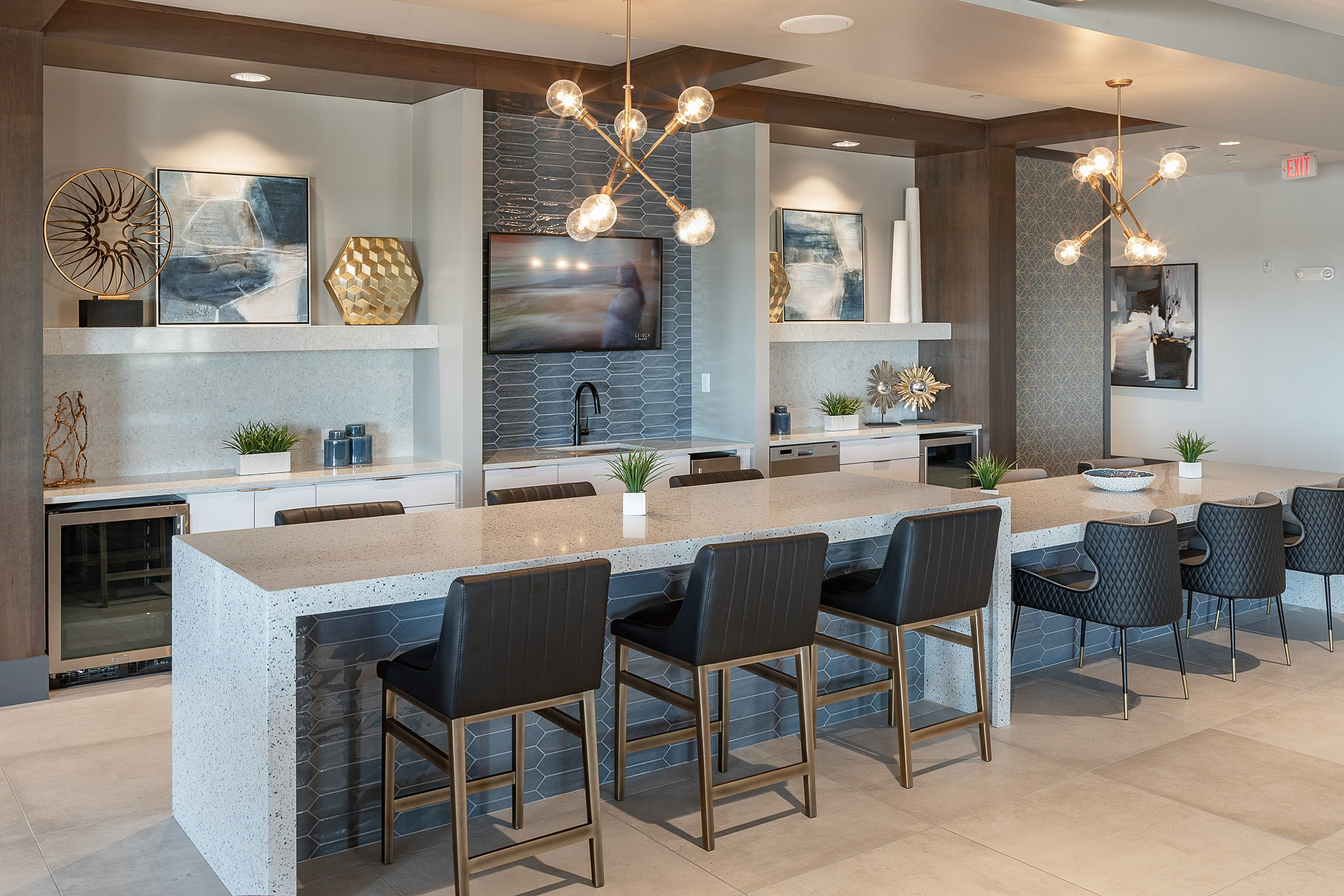 Elegant modern kitchen area featuring a spacious granite countertop, stylish pendant lighting, and sleek seating, perfect for entertaining.