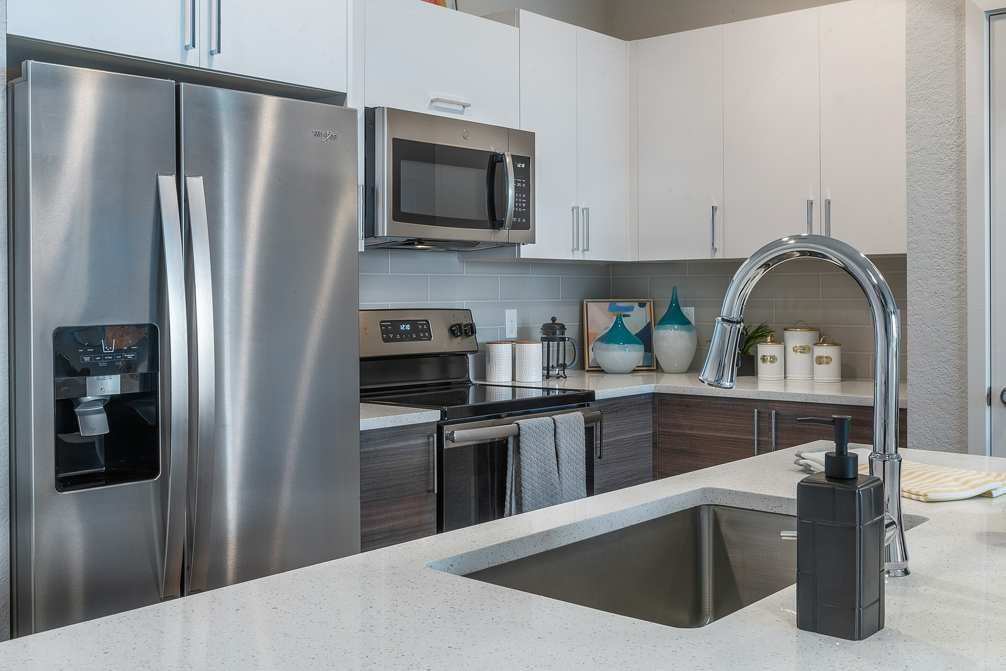 Modern kitchen with sleek stainless steel appliances, elegant quartz countertop, and stylish cabinetry, creating an inviting culinary space.
