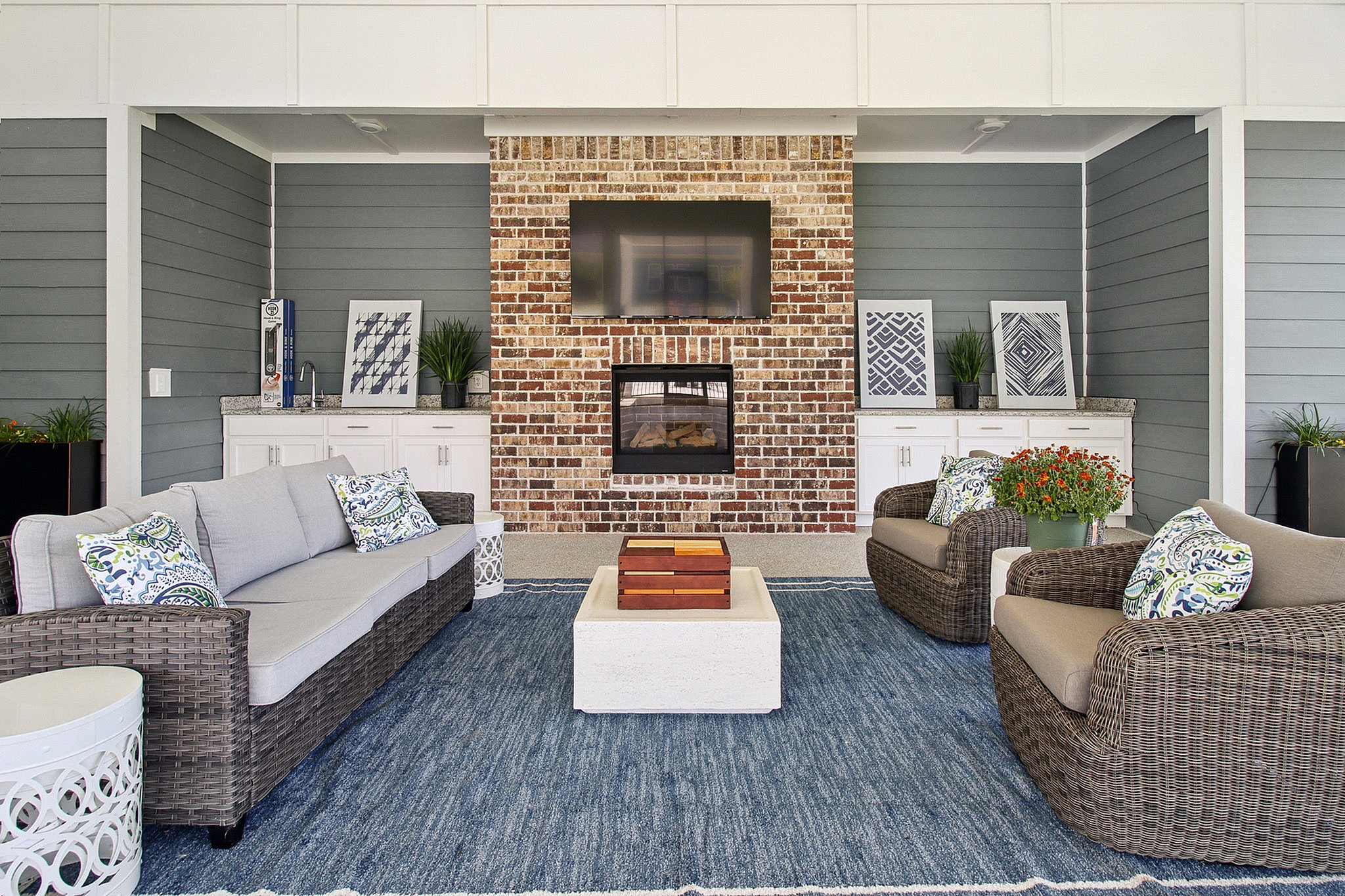 Chic outdoor living area featuring a cozy fireplace, stylish wicker furniture, and vibrant decorative accents.