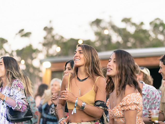 Lively outdoor gathering with cheerful people enjoying a festive atmosphere under a clear sky.