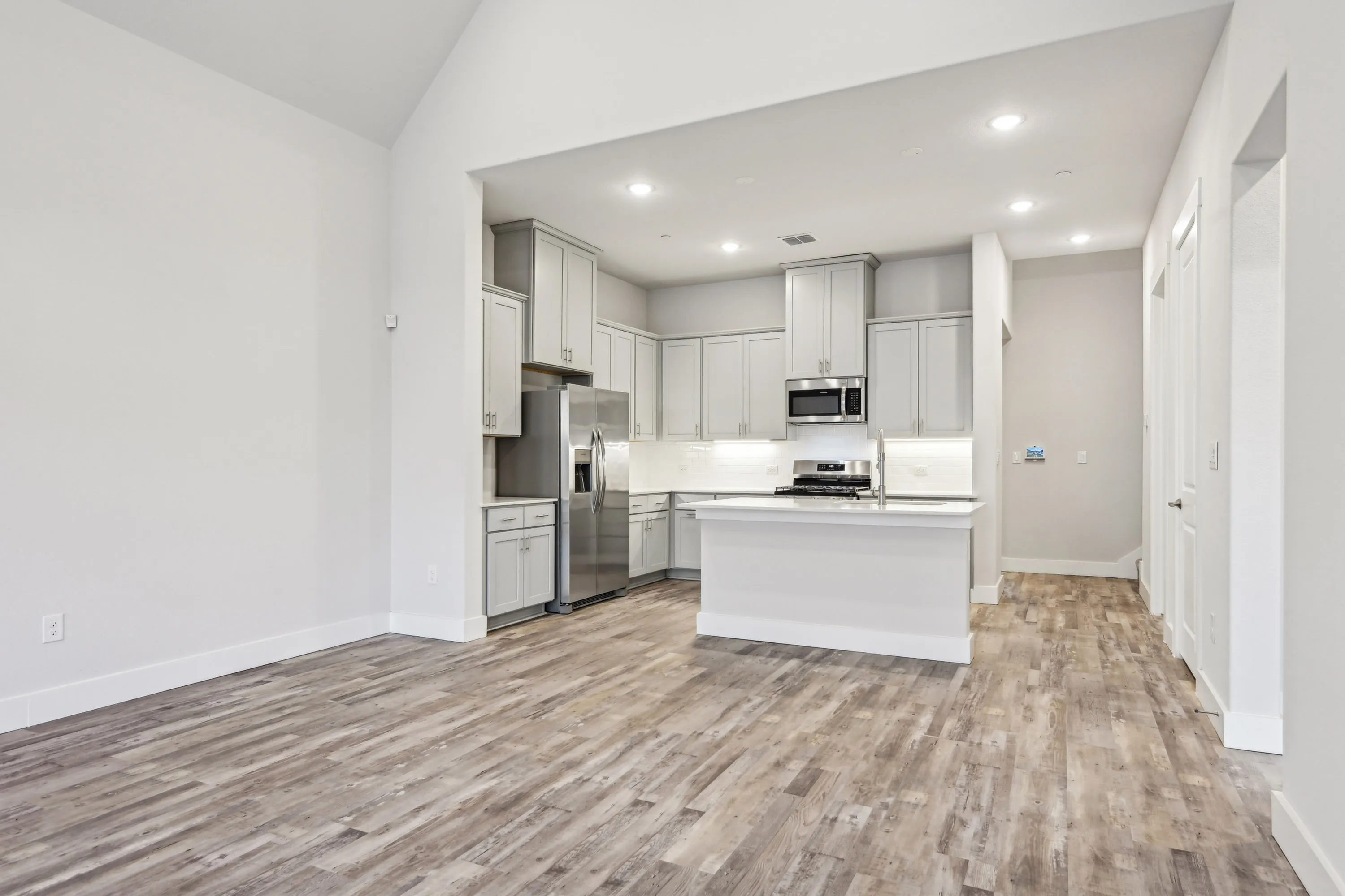 Open kitchen and living area with wood style flooring