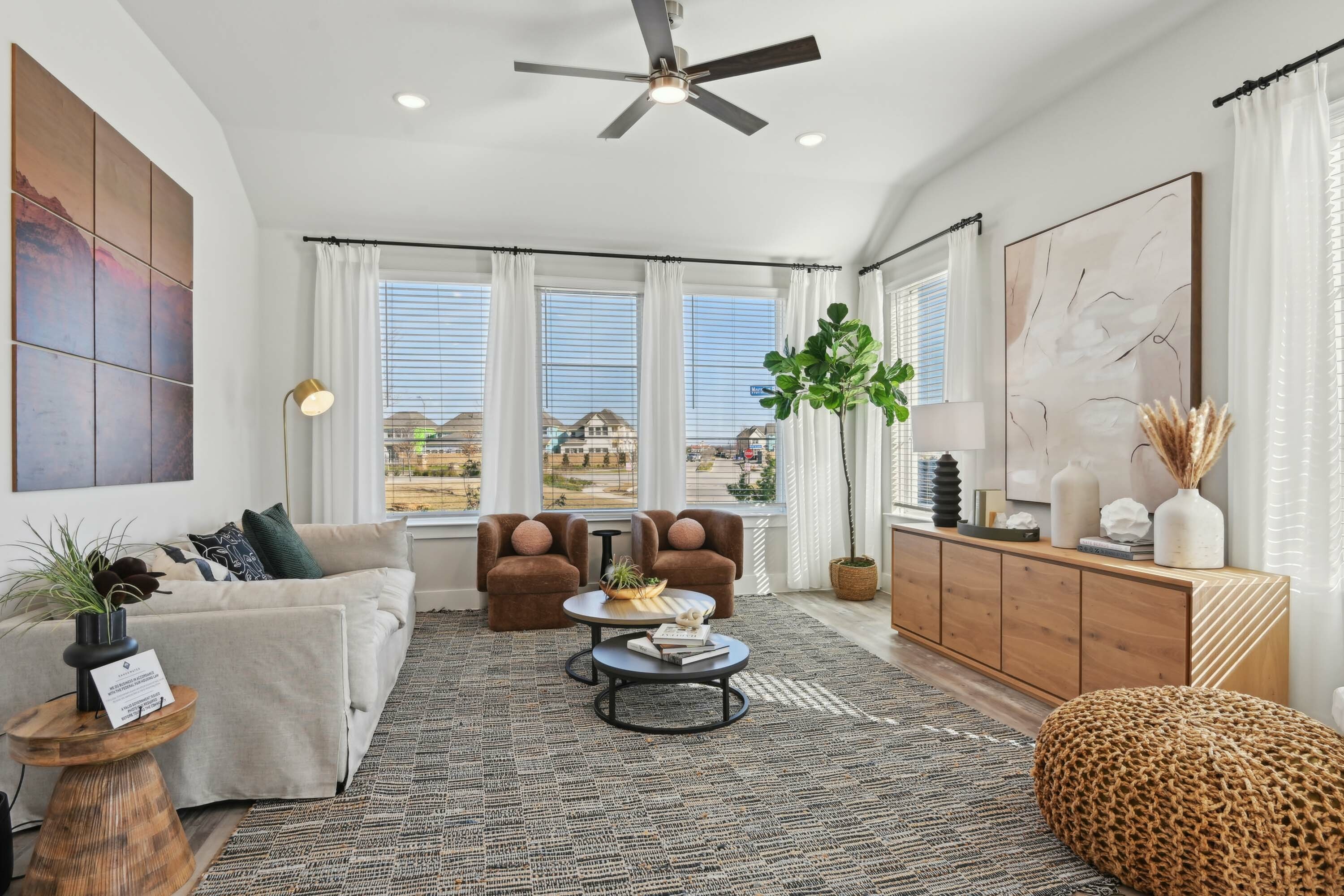 Furnished living room with vaulted ceilings and large windows