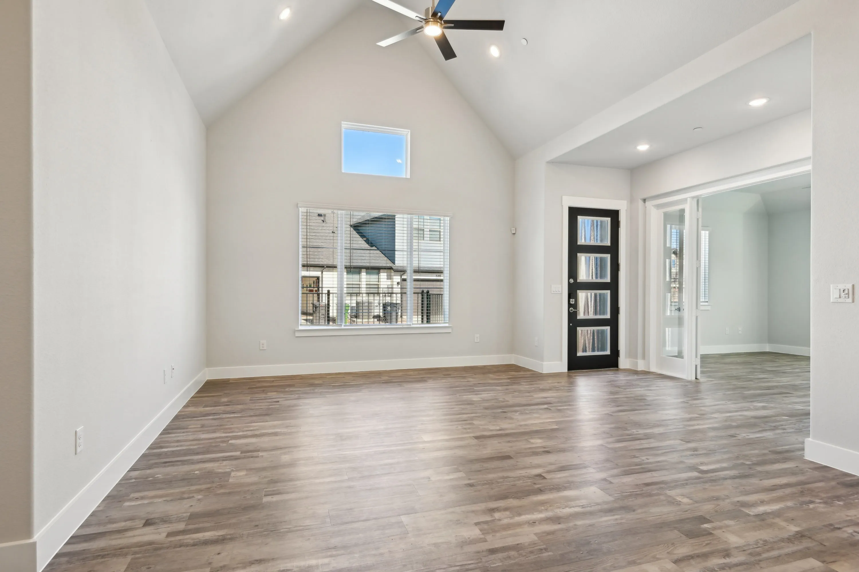 Spacious living area with vaulted ceiling and and french door opening