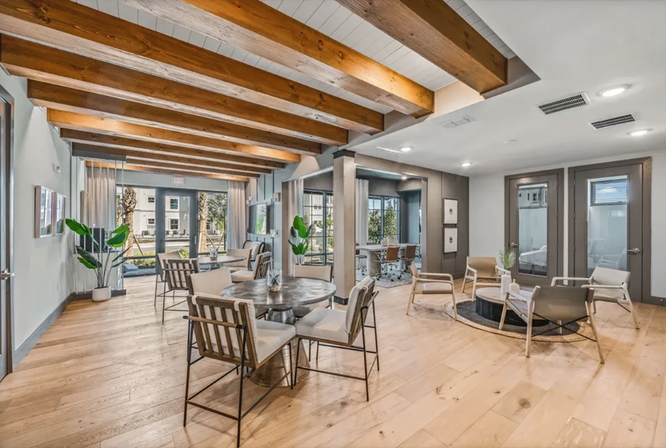Chic community lounge with wooden beams, contemporary seating, and natural light.