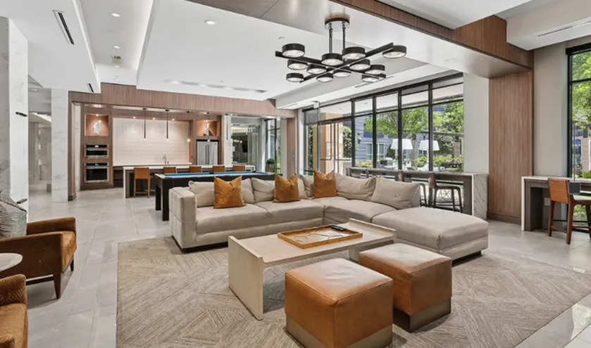 Luxurious open-concept living area with modern kitchen, stylish seating, and abundant natural light through large windows.