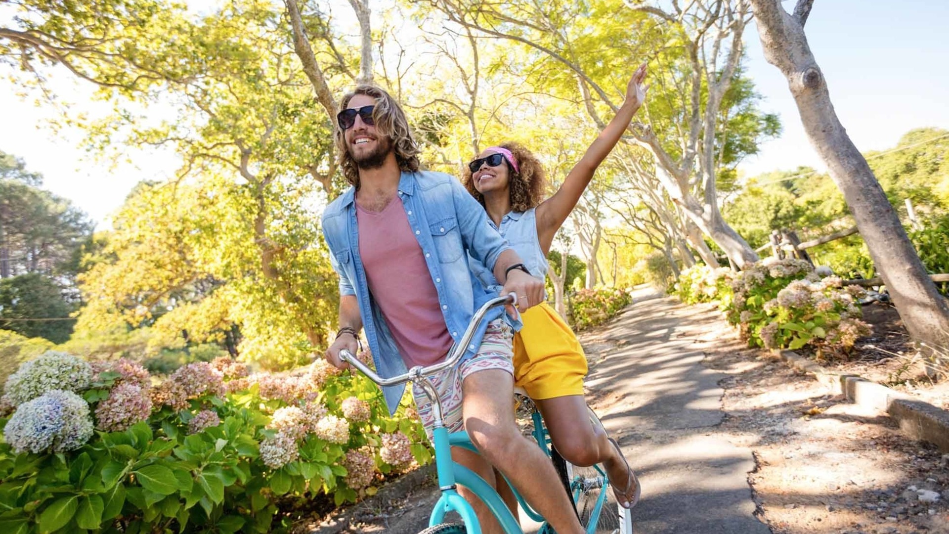 Man and woman riding a two person bicycle on a path