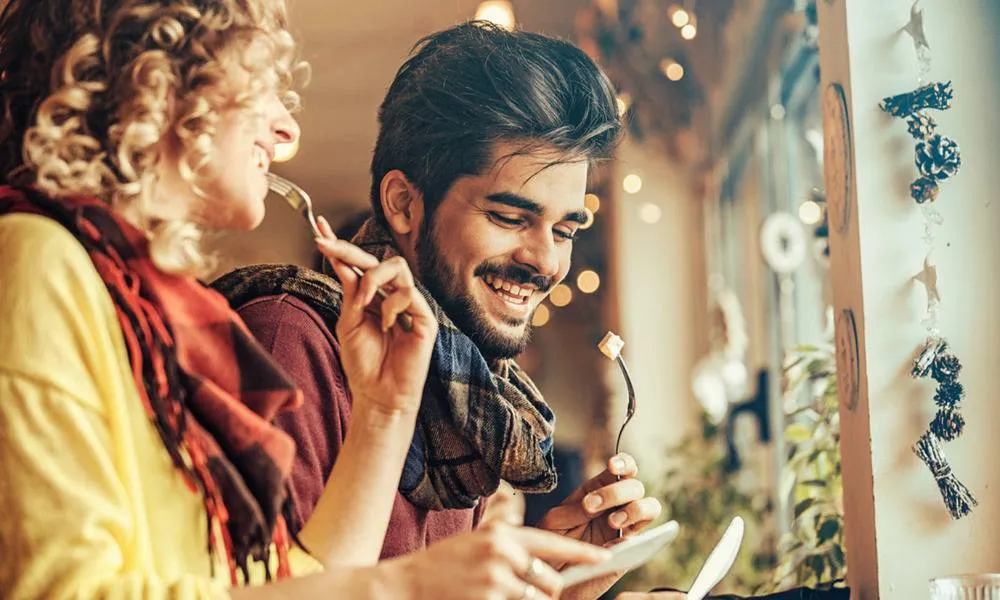 man and woman eating meal at restaurant
