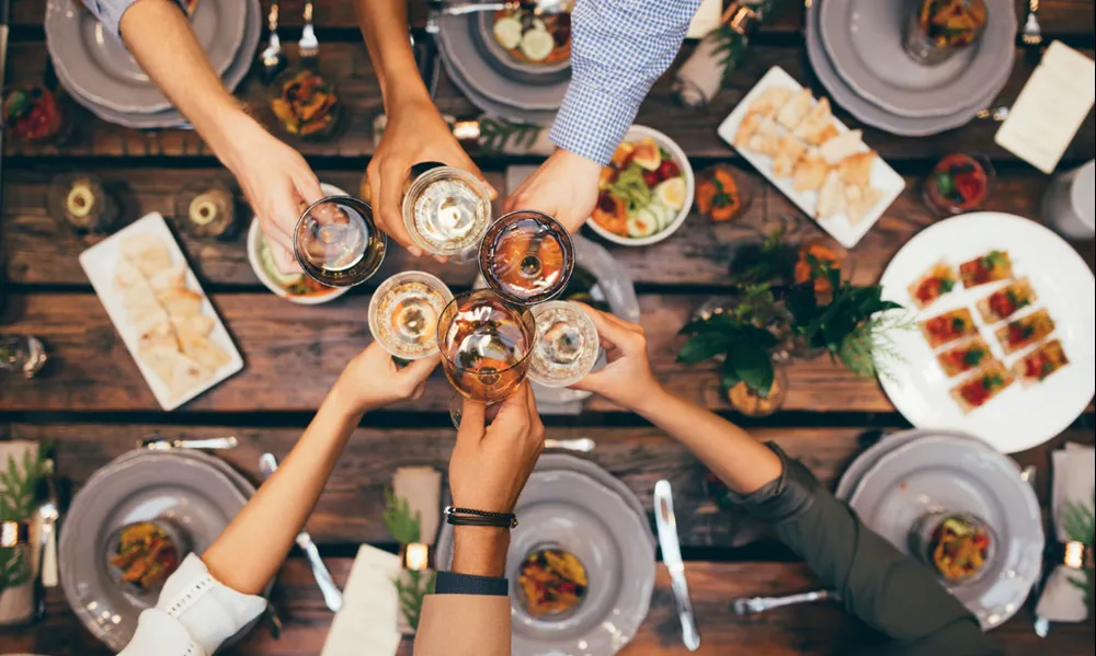 aerial shot of poeple toasting over dinner